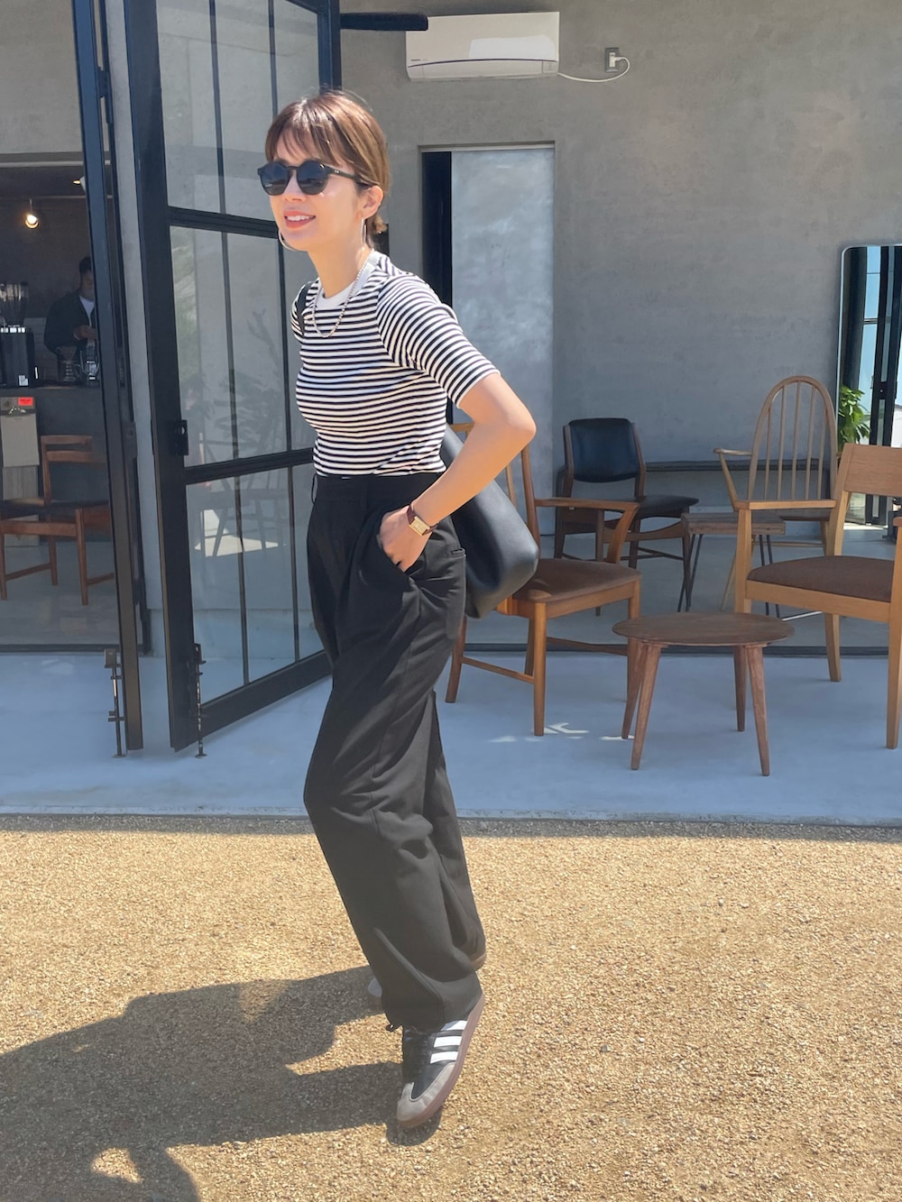 ブラック系のTシャツ/カットソー、ホワイト系のシャツ/ブラウス、ブラック系のスラックスを着用したレディースの春コーディネートの2枚目の写真