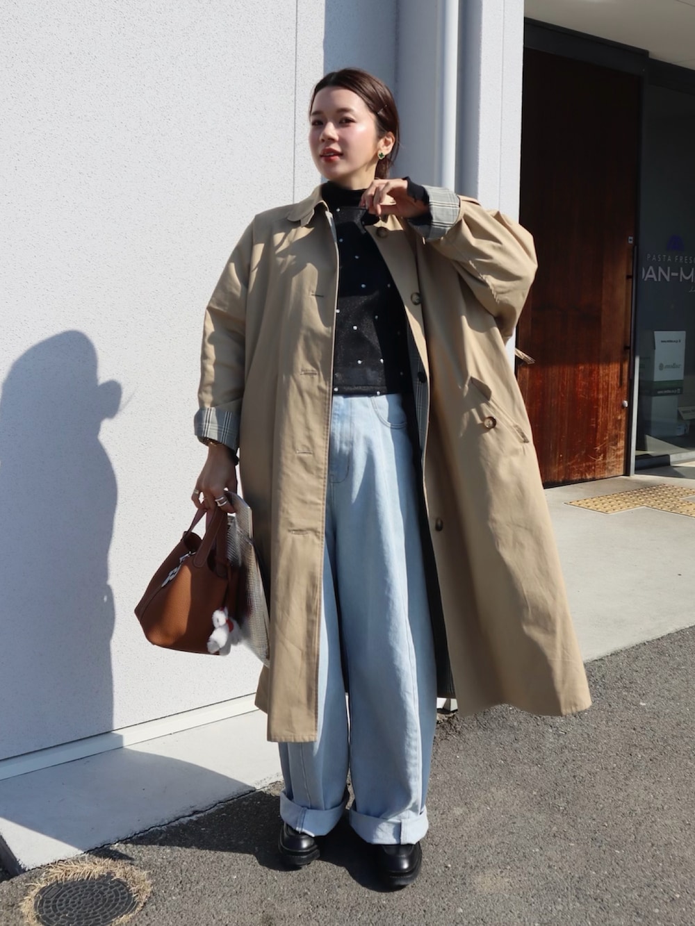 ブラック系のシャツ/ブラウス、ブルー系のデニムパンツ、ブラウン系のハンドバッグを着用したレディースの冬コーディネートの2枚目の写真