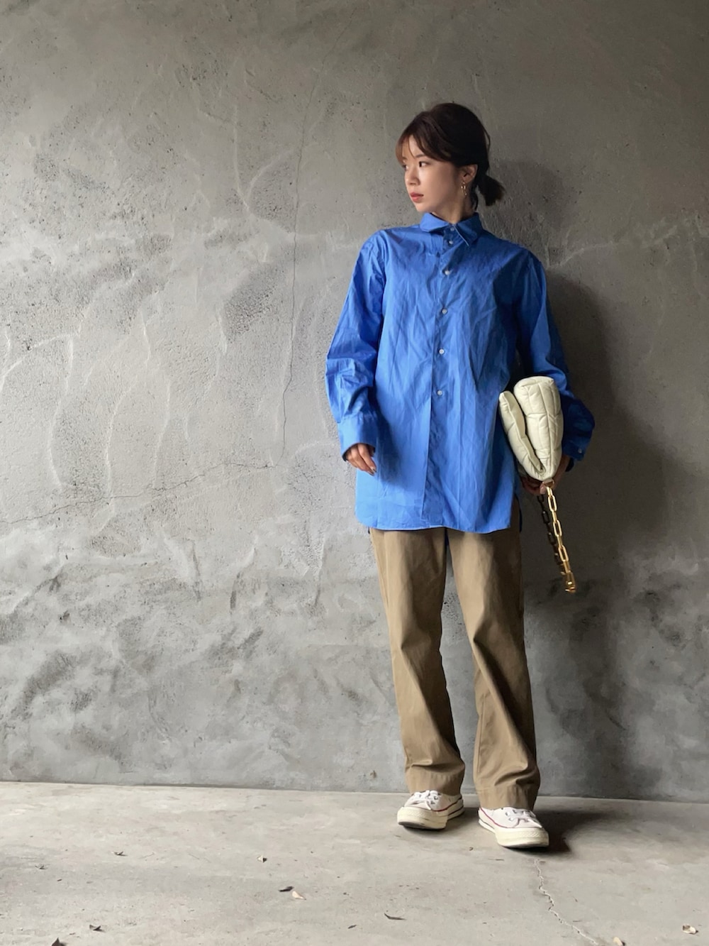 ブルー系のシャツ/ブラウス、ベージュ系のチノパンツ、ホワイト系のバッグを着用したレディースの春コーディネートの2枚目の写真