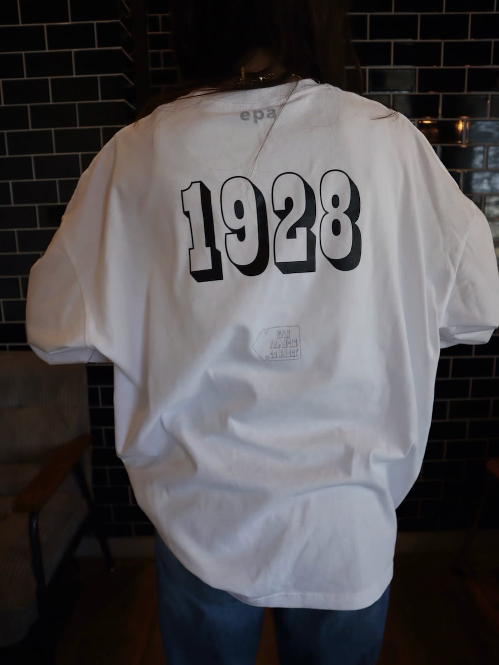 ホワイト系のTシャツ/カットソー、ブラック系のスラックス、ブラック系のスニーカーを着用したレディースの冬コーディネートの3枚目の写真