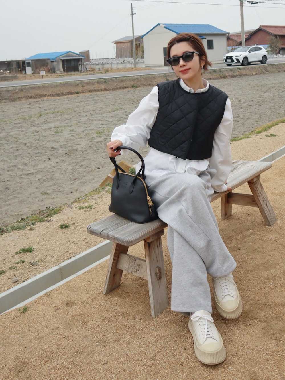 ホワイト系のシャツ/ブラウス、ブラック系のその他アウター、グレー系のスウェットパンツを着用したレディースの冬コーディネートの2枚目の写真