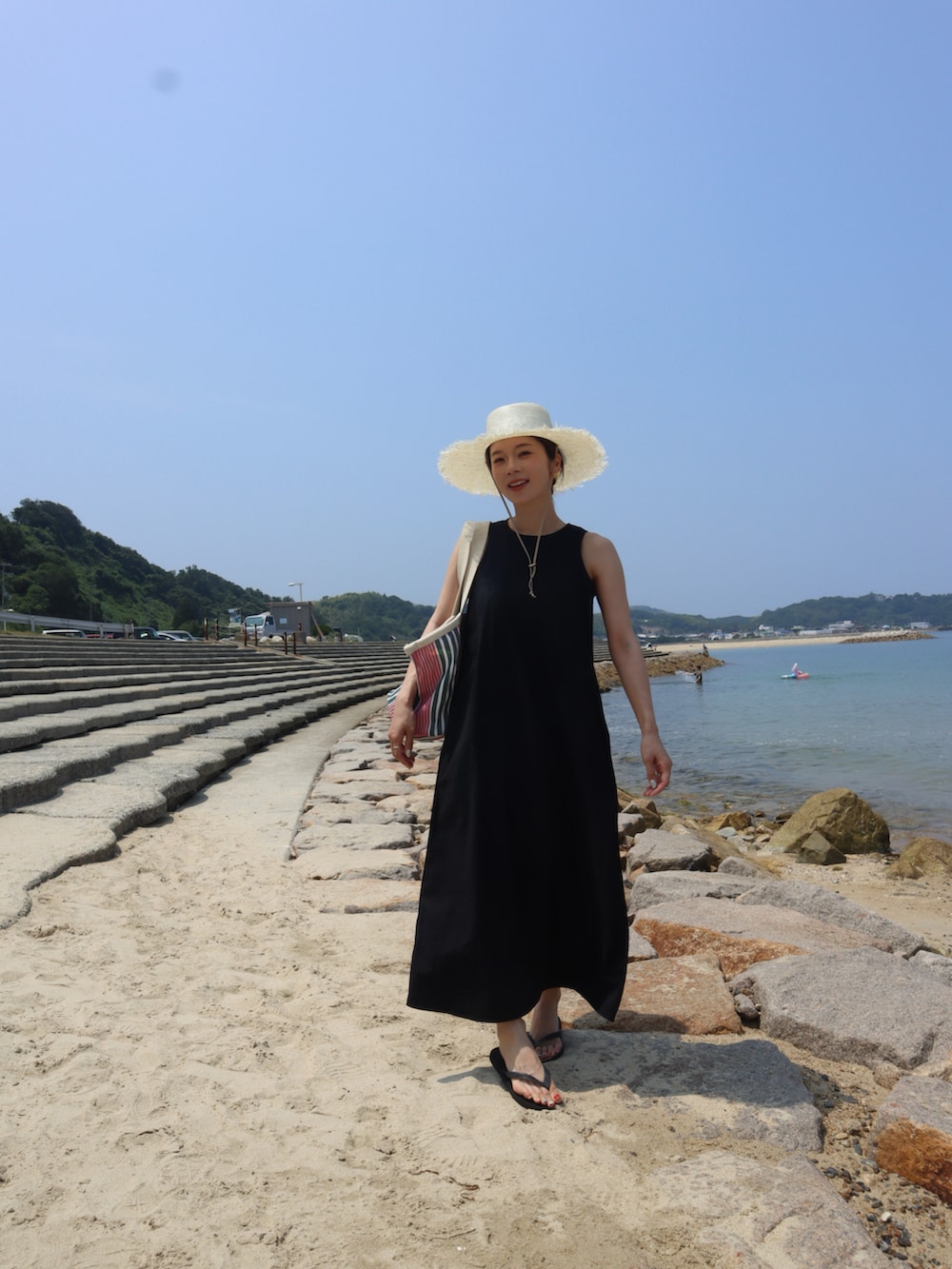 ブラック系のワンピース、ベージュ系のハットを着用したレディースの夏コーディネートの2枚目の写真