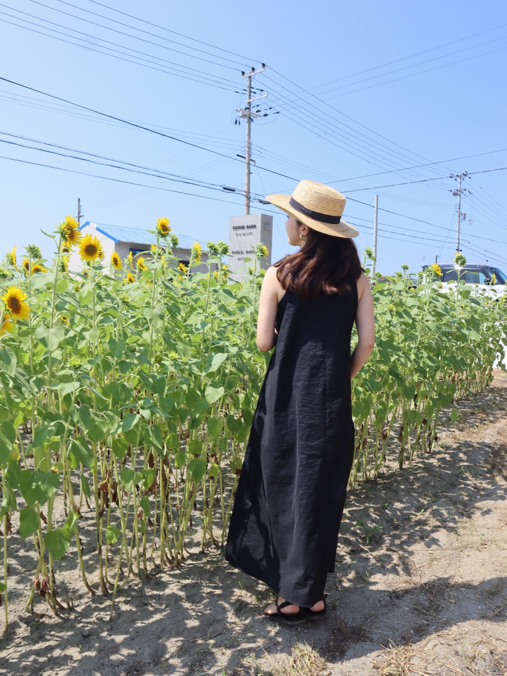 ブラック系のワンピース、ブラウン系のサンダルを着用したレディースの夏コーディネートの3枚目の写真