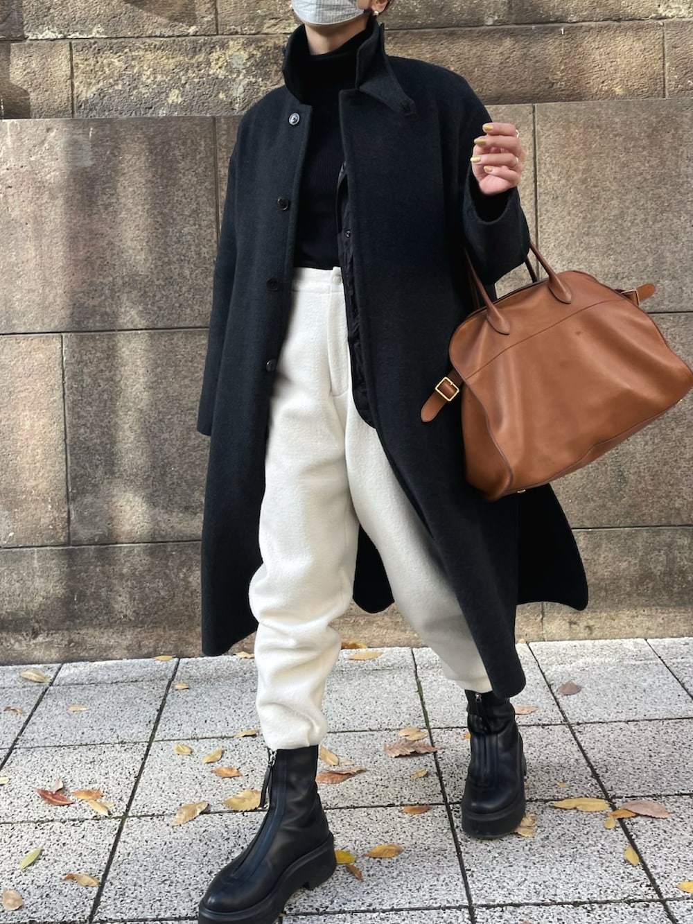 グレー系のステンカラーコート、ホワイト系のその他パンツ、ブラック系のブーツを着用したレディースの冬コーディネートの2枚目の写真