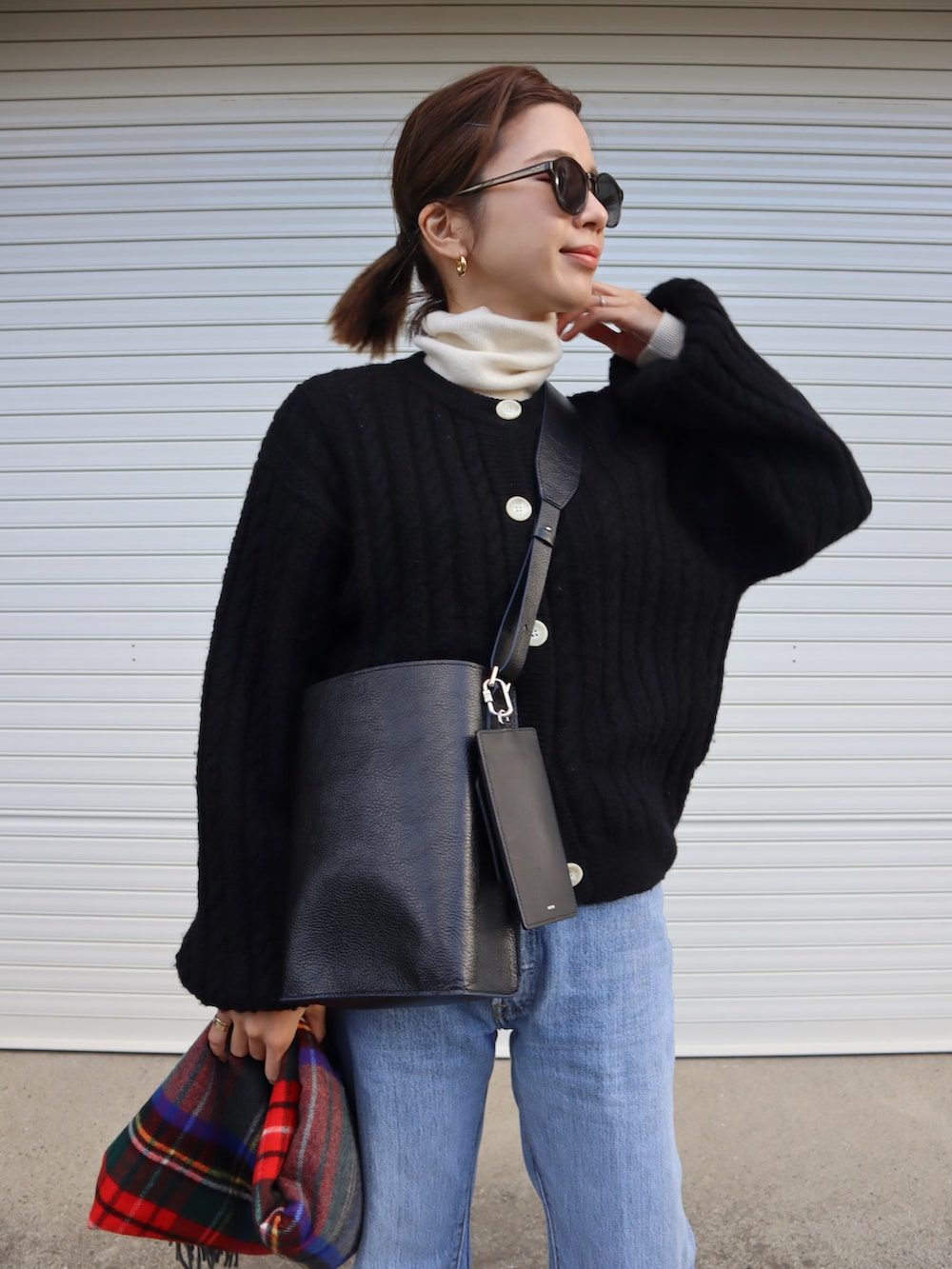 ブラック系のカーディガン/ボレロ、ブラック系のブーツ、ブラック系のショルダーバッグを着用したレディースの冬コーディネートの2枚目の写真