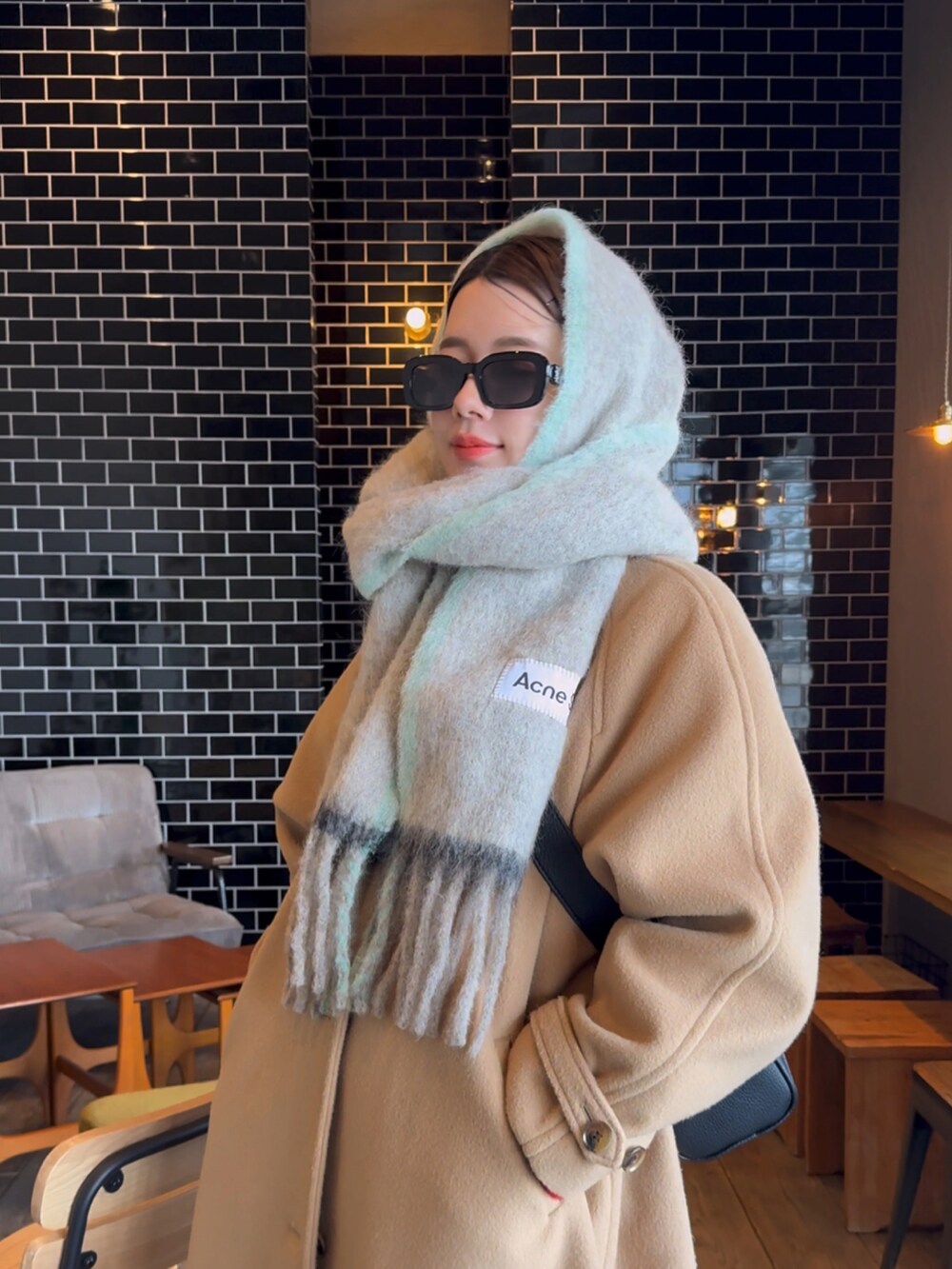 ベージュ系のその他アウター、ベージュ系のスニーカー、ベージュ系のストール/ショールを着用したレディースの冬コーディネートの2枚目の写真