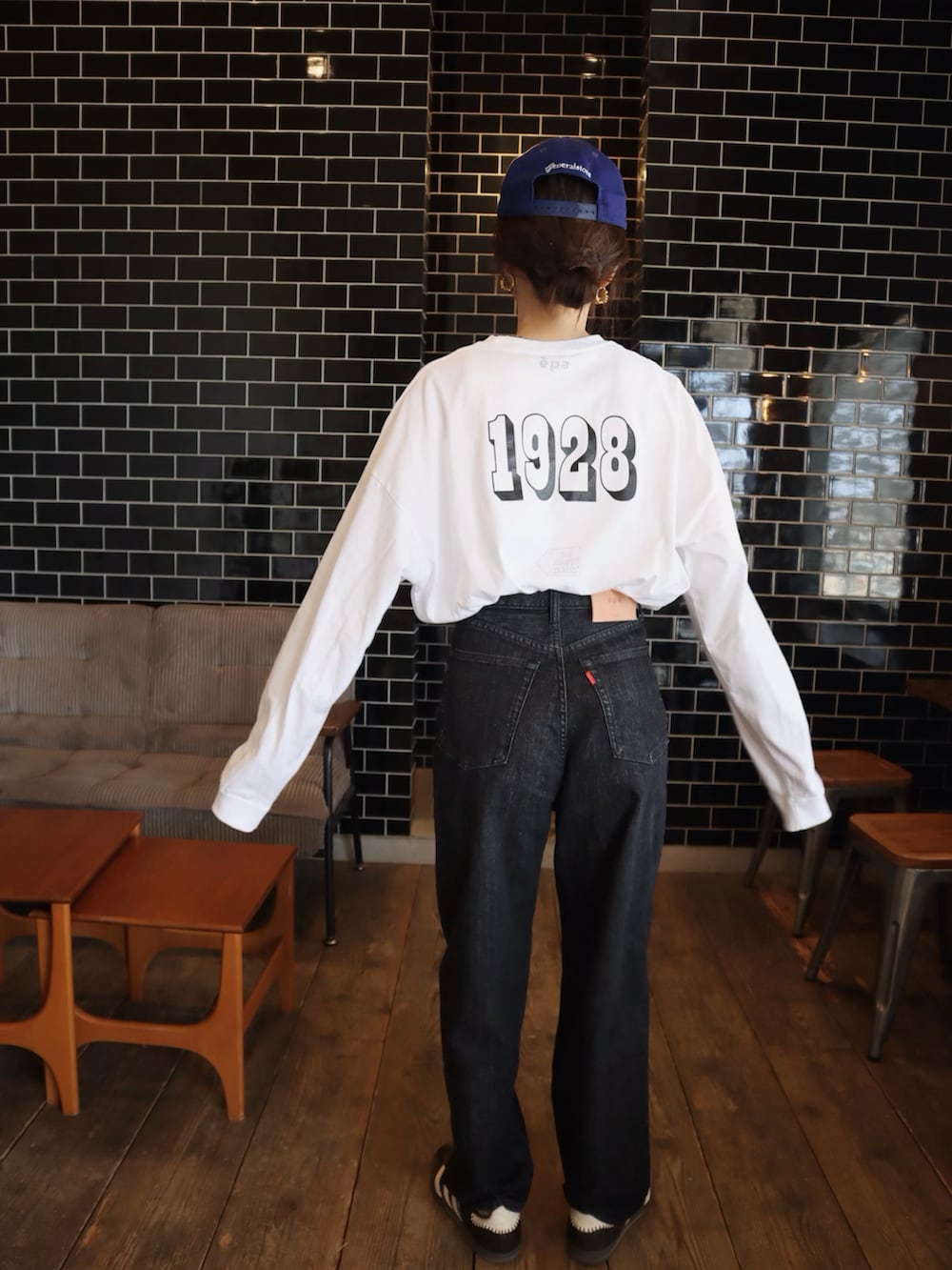 ブラウン系のスニーカー、ホワイト系のTシャツ/カットソー、ブラック系のデニムパンツを着用したレディースの冬コーディネートの3枚目の写真