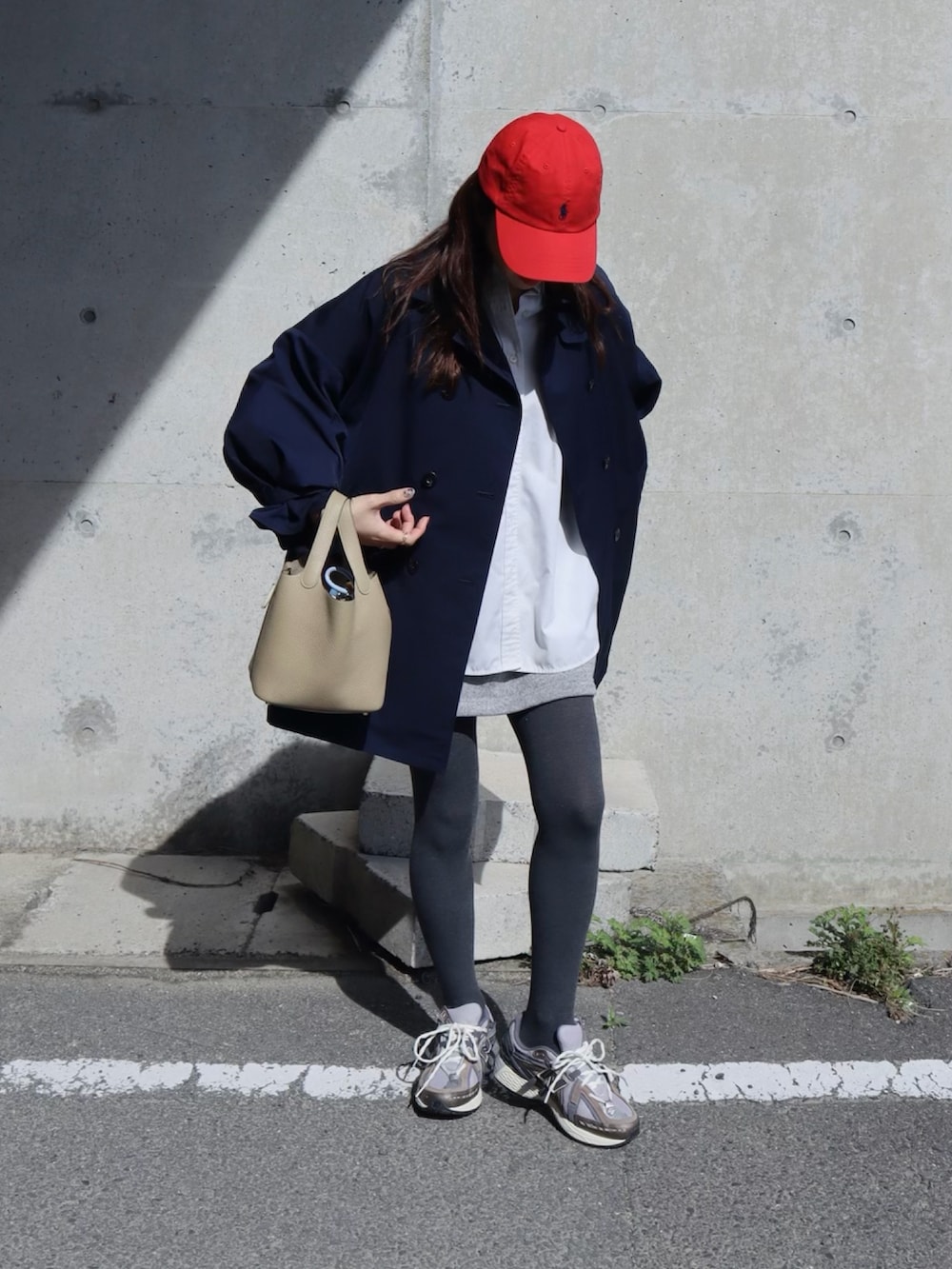 ブラウン系のスニーカー、ブルー系のトレンチコート、グレー系のタイツ/ストッキングを着用したレディースの春コーディネートの2枚目の写真