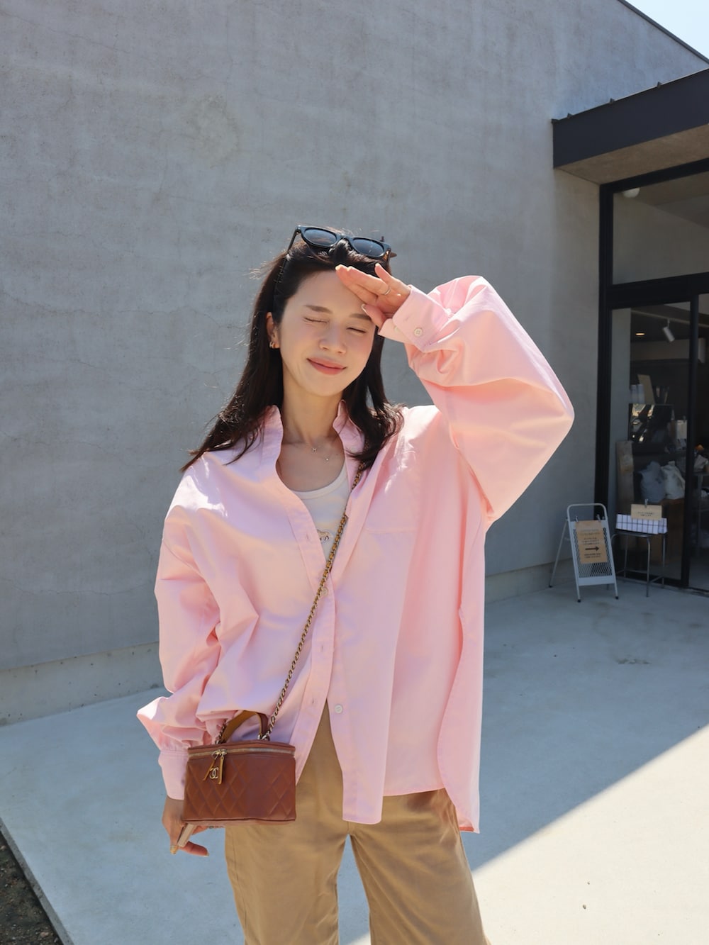 シルバー系のスニーカー、ピンク系のシャツ/ブラウス、ホワイト系のタンクトップを着用したレディースの秋コーディネートの2枚目の写真