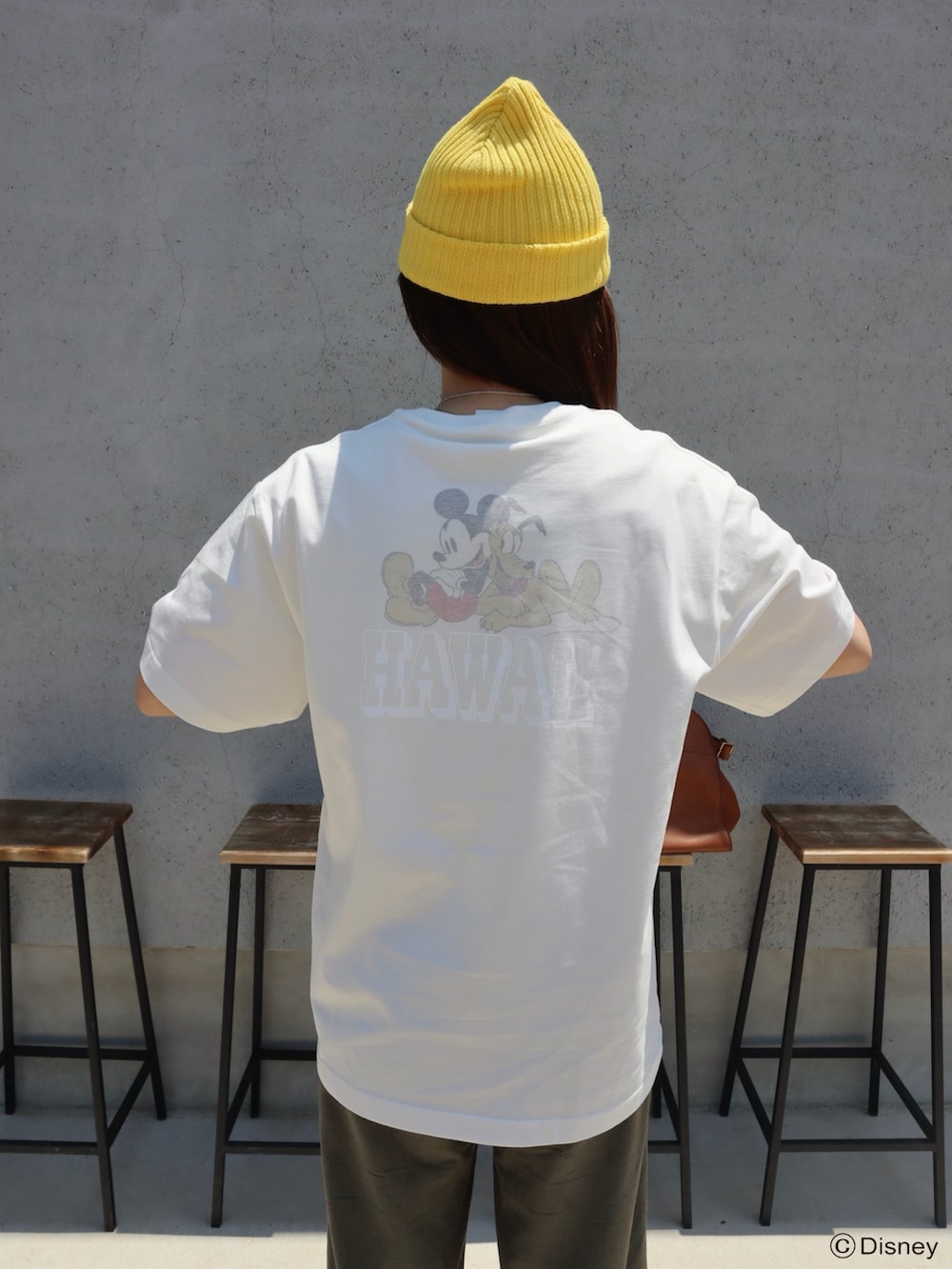 ホワイト系のTシャツ/カットソー、ブラウン系のハンドバッグ、シルバー系のスニーカーを着用したレディースの夏コーディネートの3枚目の写真