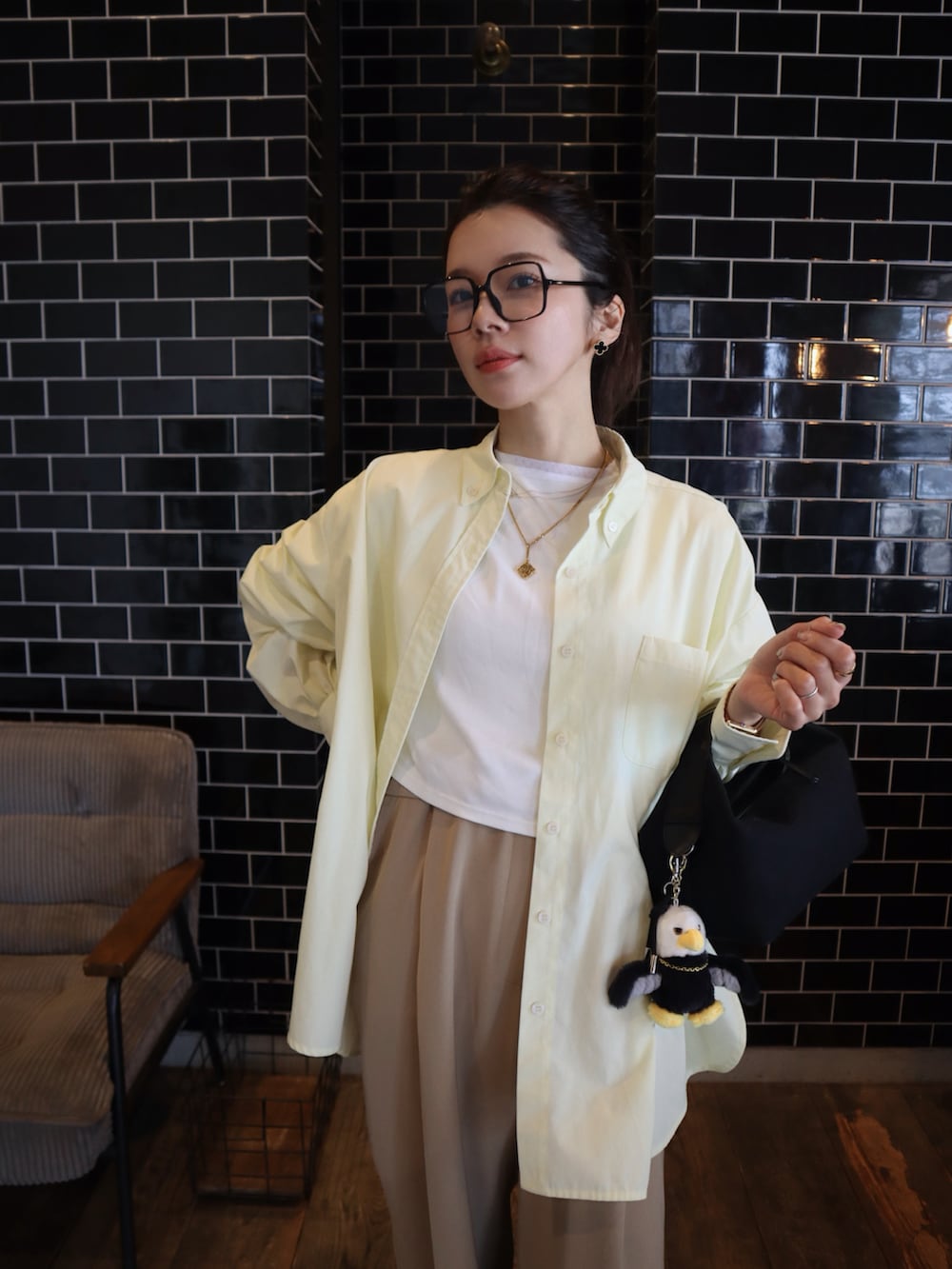 イエロー系のシャツ/ブラウス、ホワイト系のTシャツ/カットソー、ベージュ系のスラックスを着用したレディースの春コーディネートの2枚目の写真