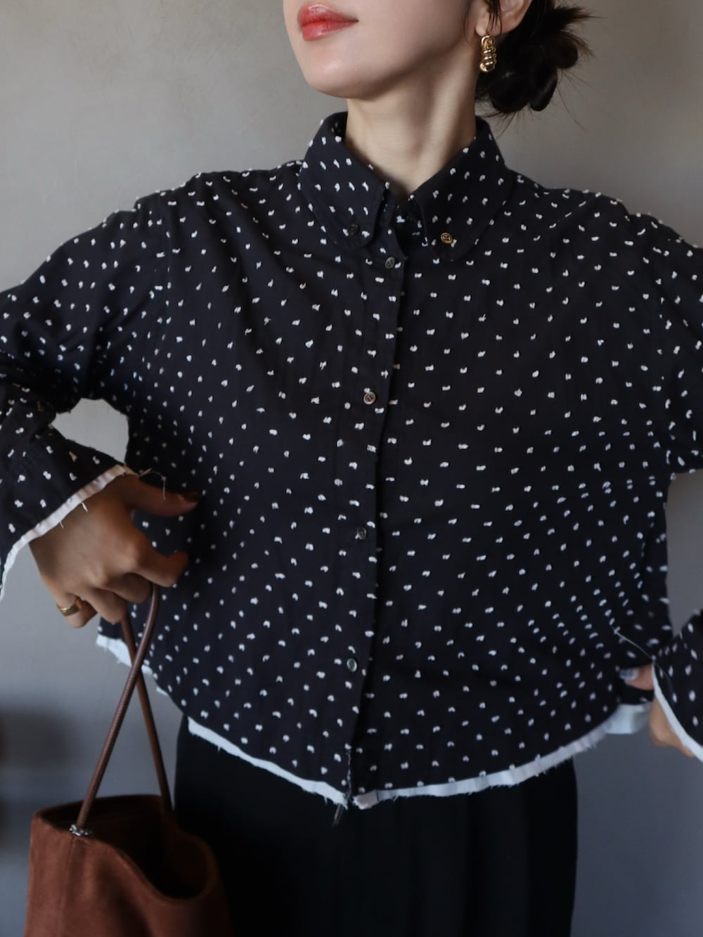 ブラック系のシャツ/ブラウス、ブラック系のスラックス、ブラウン系のハンドバッグを着用したレディースの冬コーディネートの2枚目の写真