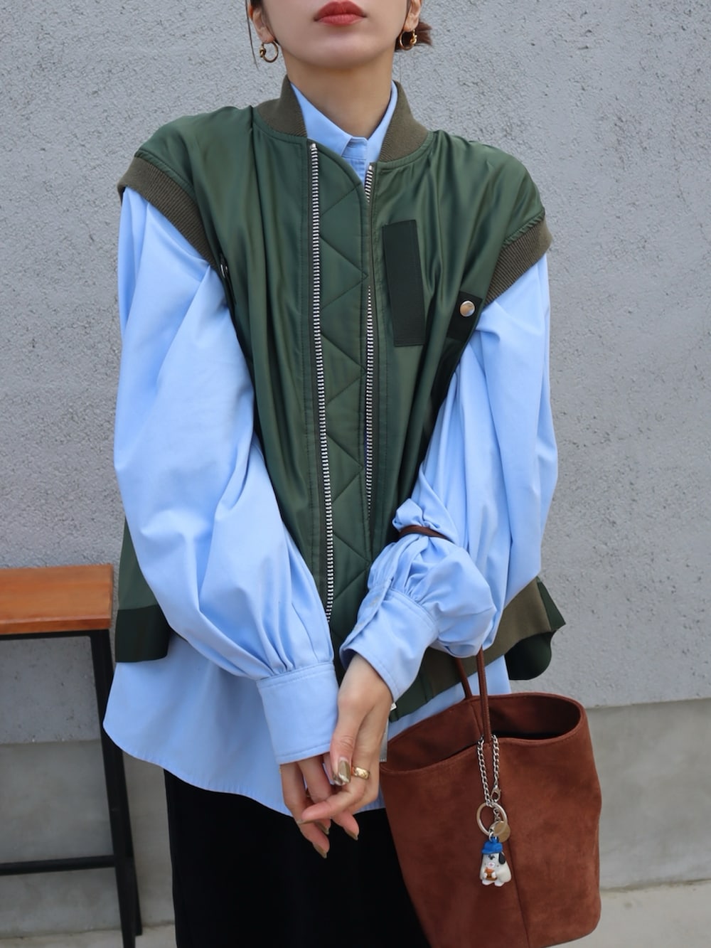 ブラウン系のハンドバッグ、ブルー系のシャツ/ブラウス、グレー系のタイツ/ストッキングを着用したレディースの冬コーディネートの2枚目の写真