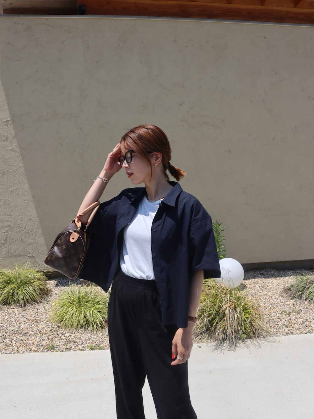 ブルー系のシャツ/ブラウス、ブラック系のスラックス、その他のスニーカーを着用したレディースの春コーディネートの2枚目の写真