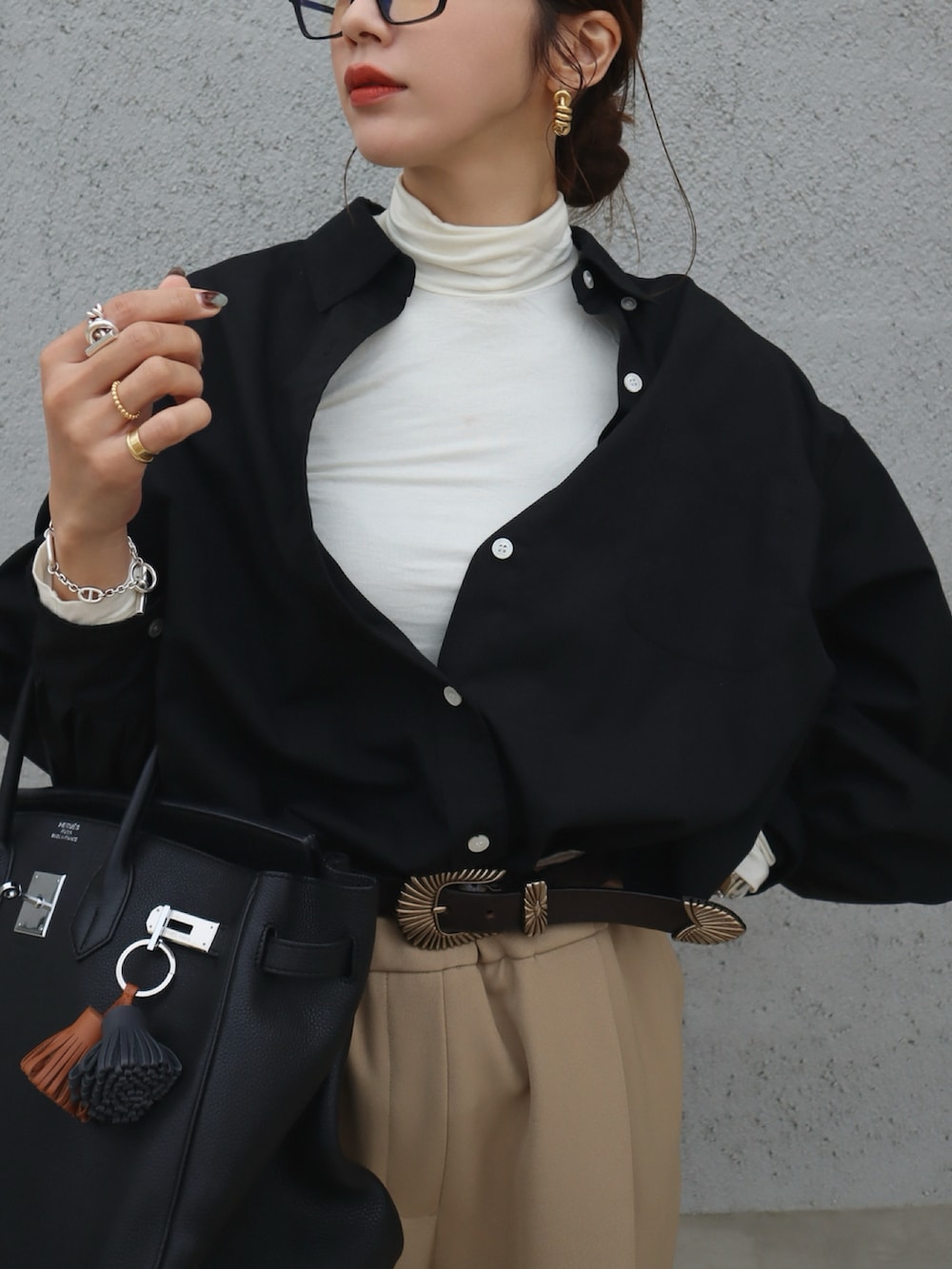 ブラック系のシャツ/ブラウス、ベージュ系のスラックス、ピンク系のチークを着用したレディースの春コーディネートの2枚目の写真