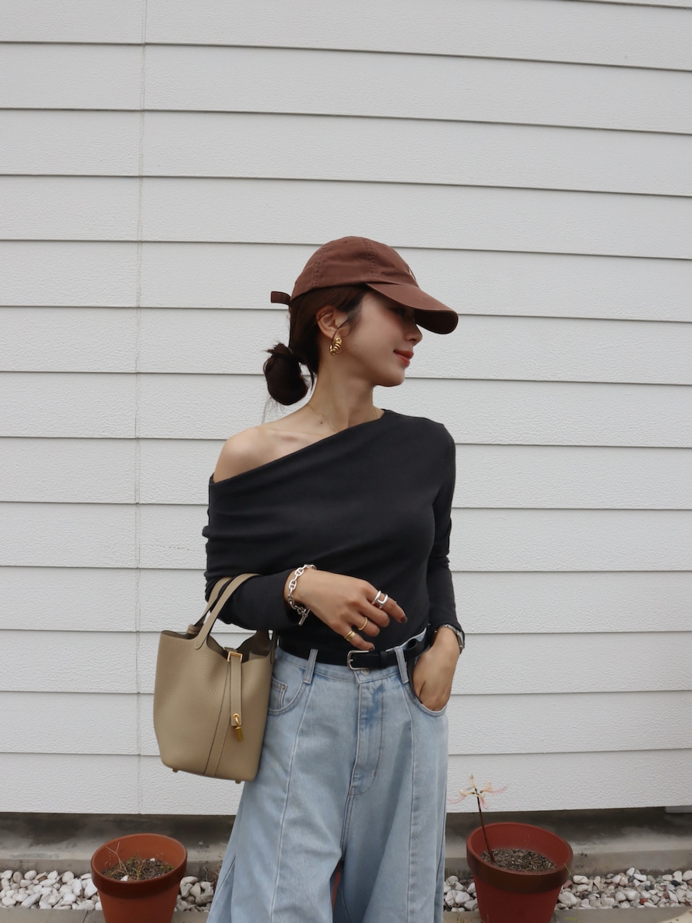 グレー系のTシャツ/カットソー、ブルー系のデニムパンツ、ブラウン系のスニーカーを着用したレディースの秋コーディネートの2枚目の写真