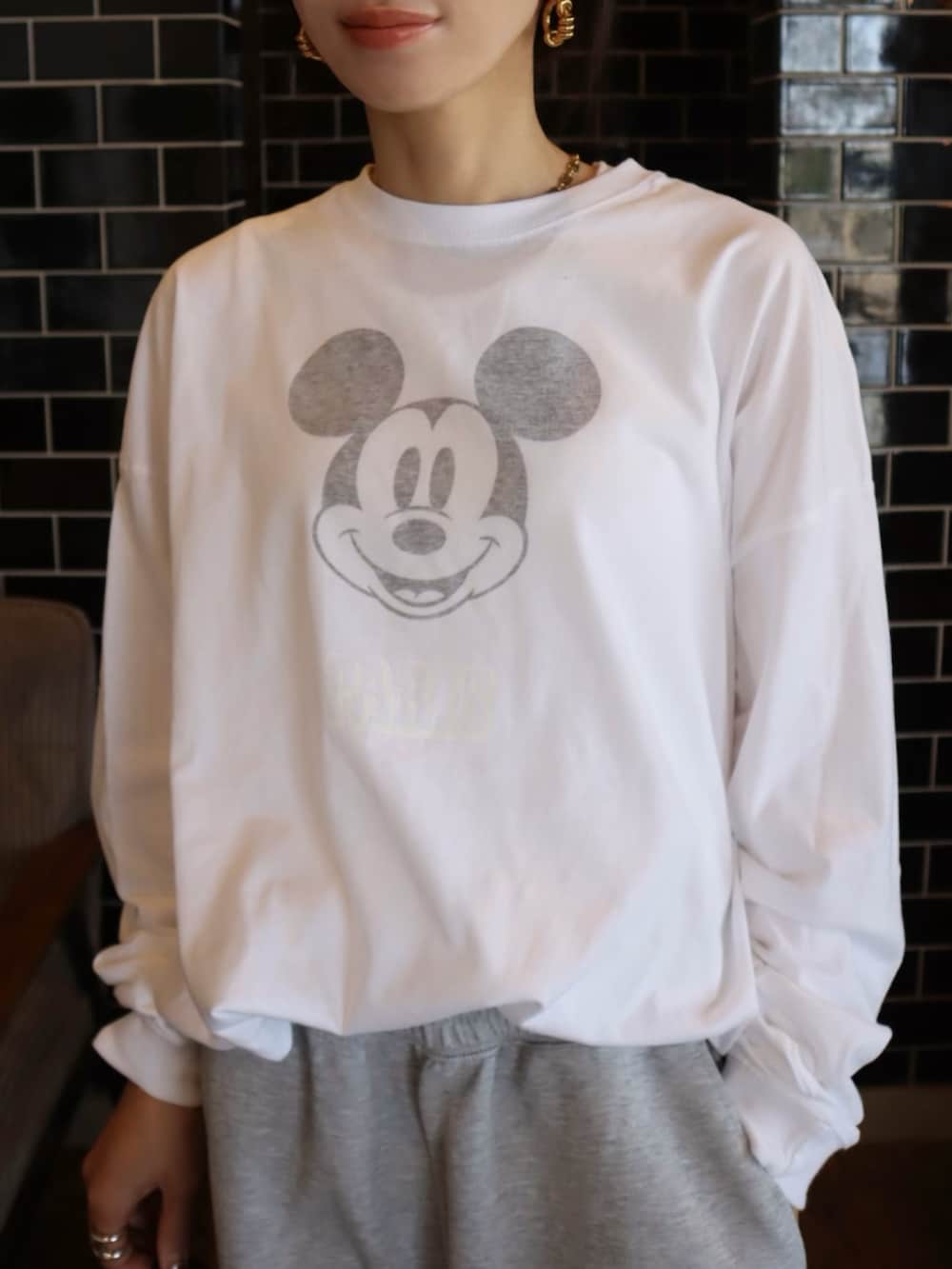 ブラウン系のスニーカー、ホワイト系のTシャツ/カットソー、グレー系のスウェットパンツを着用したレディースの冬コーディネートの3枚目の写真