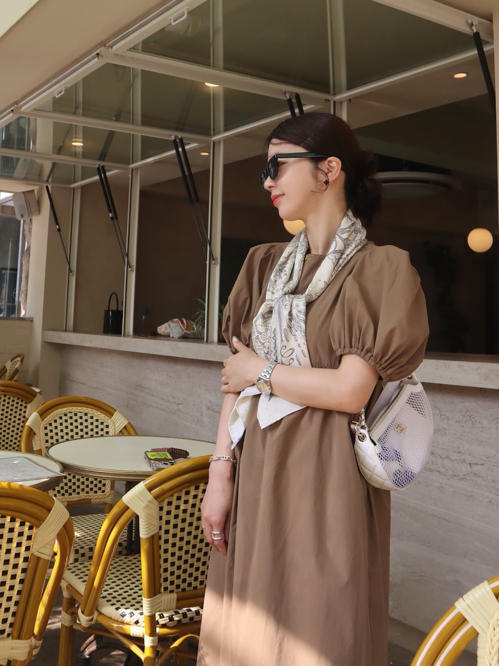 ブラウン系のワンピース、ホワイト系のストール/ショール、ベージュ系のコンシーラーを着用したレディースの夏コーディネートの3枚目の写真