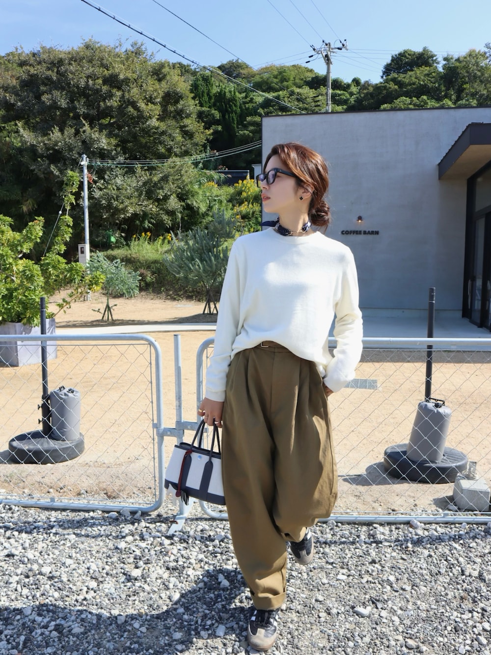 ベージュ系のその他パンツ、ホワイト系のニット/セーター、ブラック系のスニーカーを着用したレディースの秋コーディネートの3枚目の写真