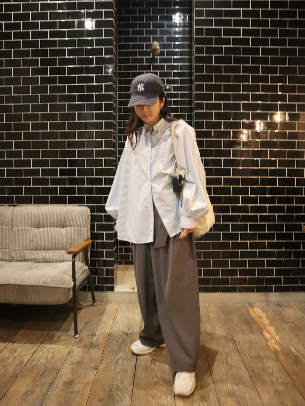 ホワイト系のスニーカー、ブルー系のシャツ/ブラウス、グレー系のスラックスを着用したレディースの冬コーディネートの2枚目の写真