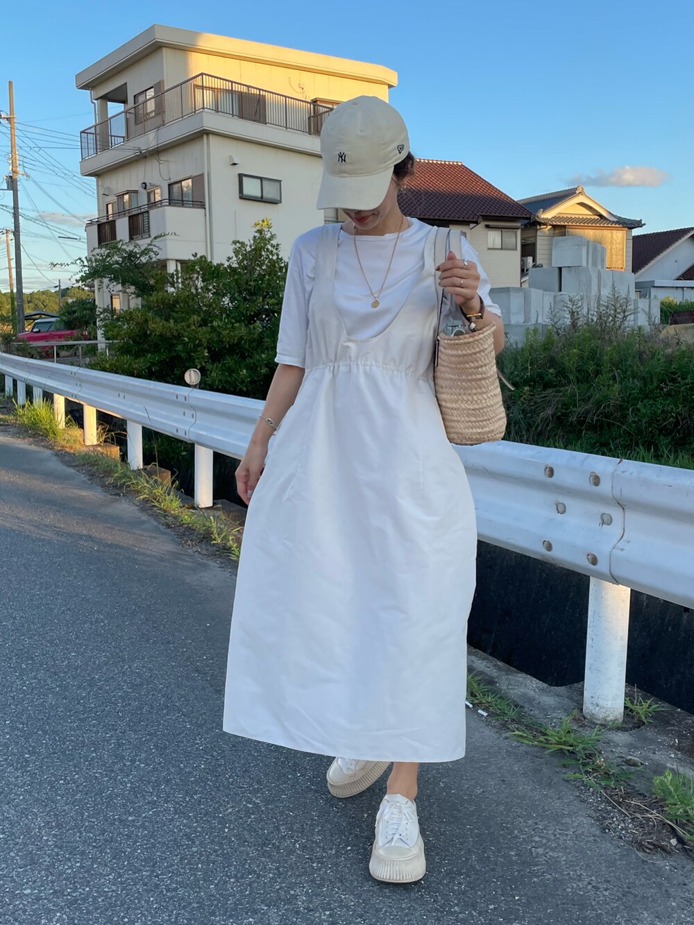 ホワイト系のTシャツ/カットソー、ホワイト系のジャンパースカート、ホワイト系のスニーカーを着用したレディースの夏コーディネートの2枚目の写真