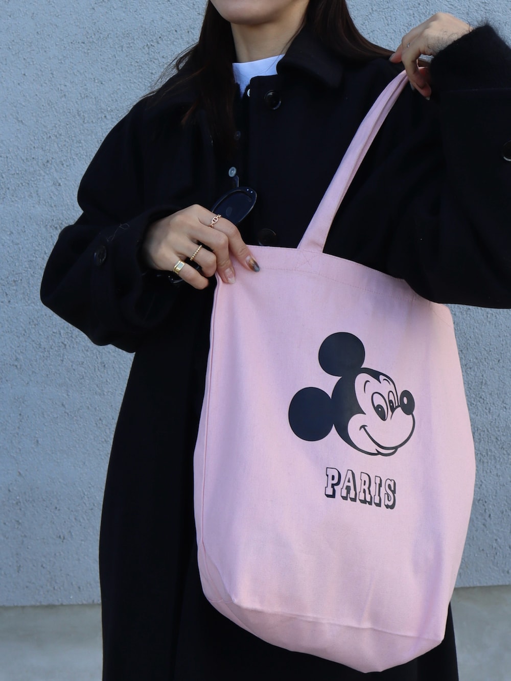 ブラック系のその他アウター、ブラック系のローファー、ピンク系のトートバッグを着用したレディースの冬コーディネートの2枚目の写真