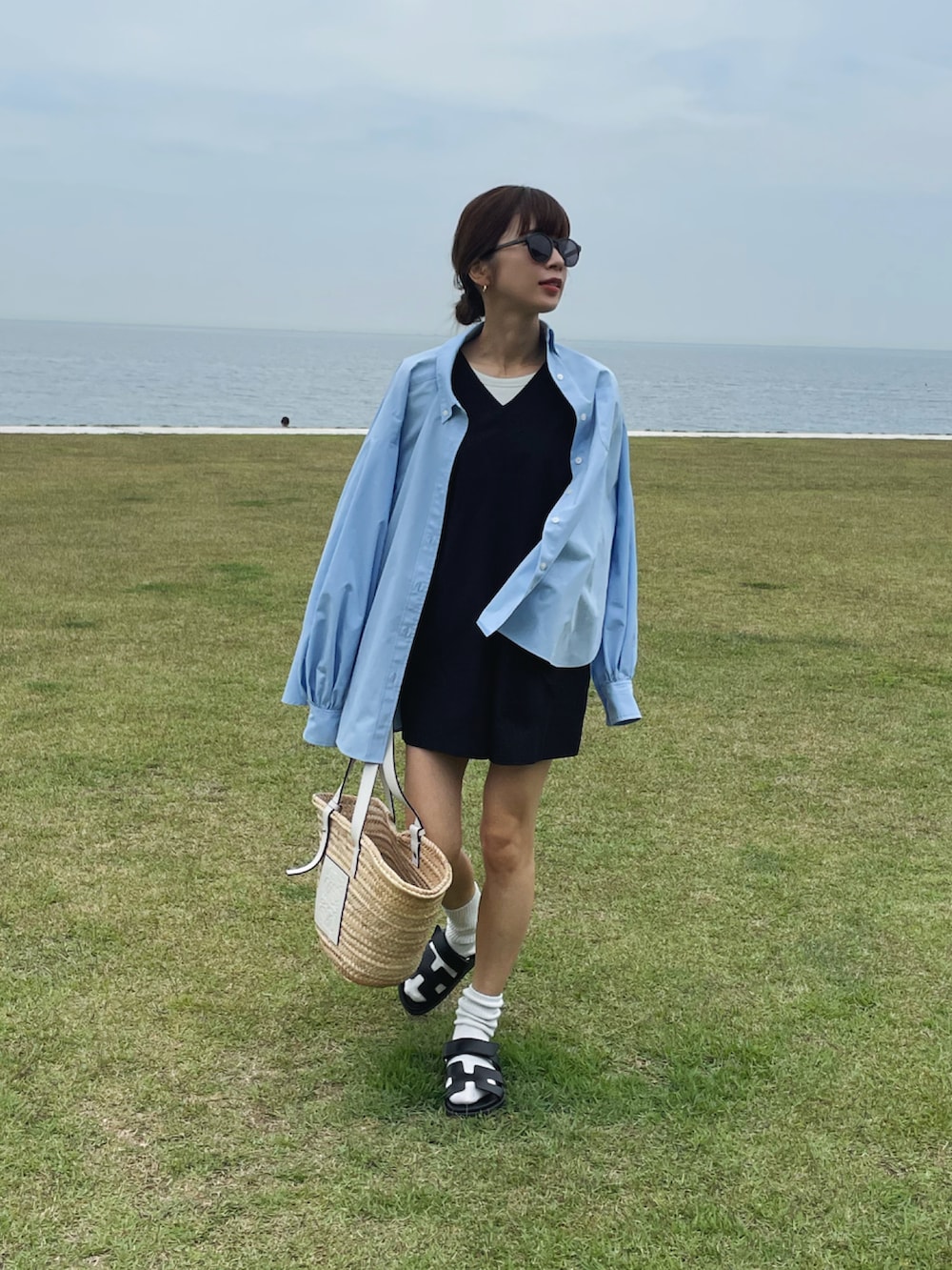 ブルー系のシャツ/ブラウス、ホワイト系のかごバッグ、ブラック系のサンダルを着用したレディースの夏コーディネートの3枚目の写真