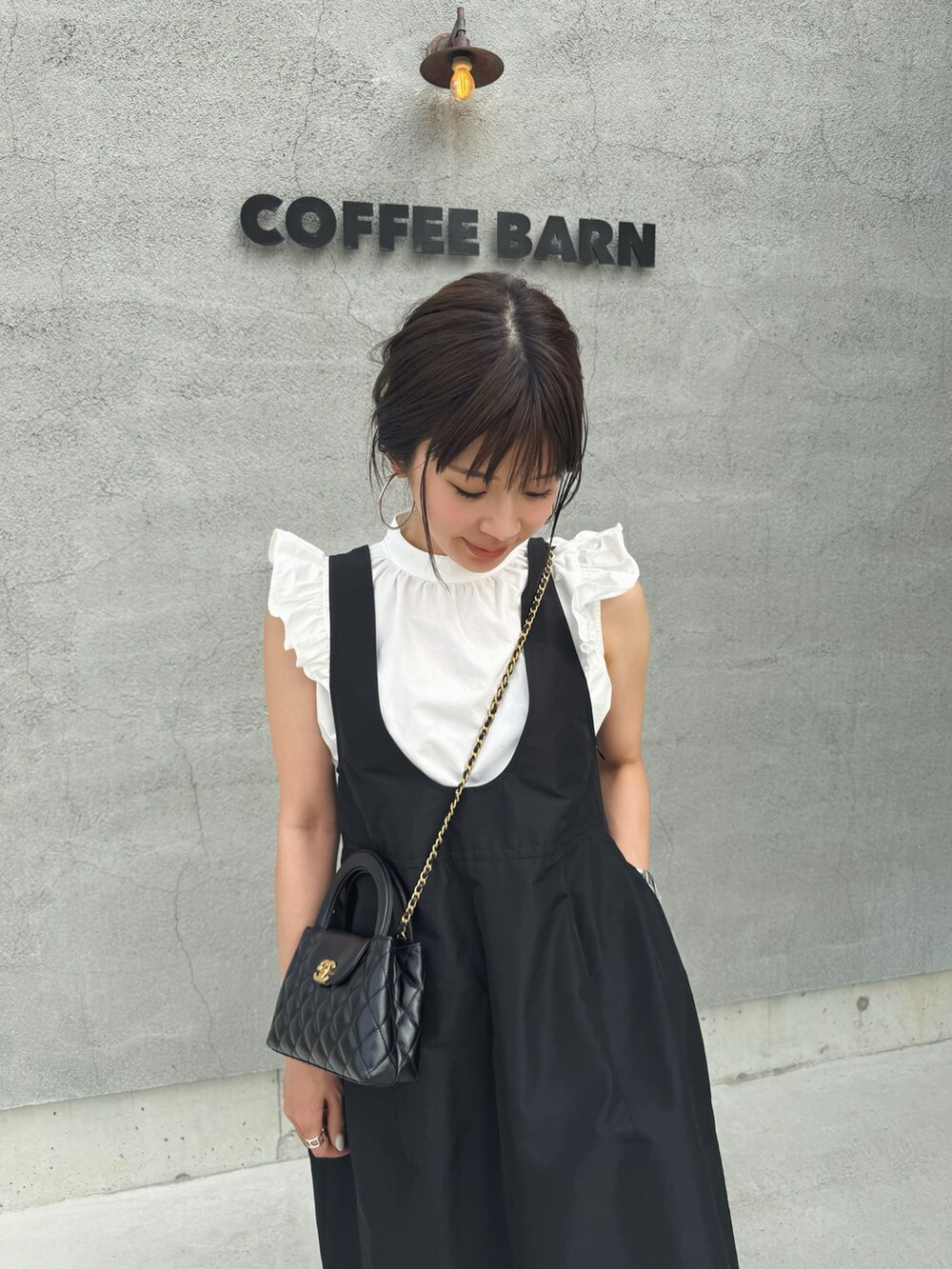 ホワイト系のその他トップス、ブラック系のジャンパースカート、ベージュ系のバレエシューズを着用したレディースの春コーディネートの2枚目の写真