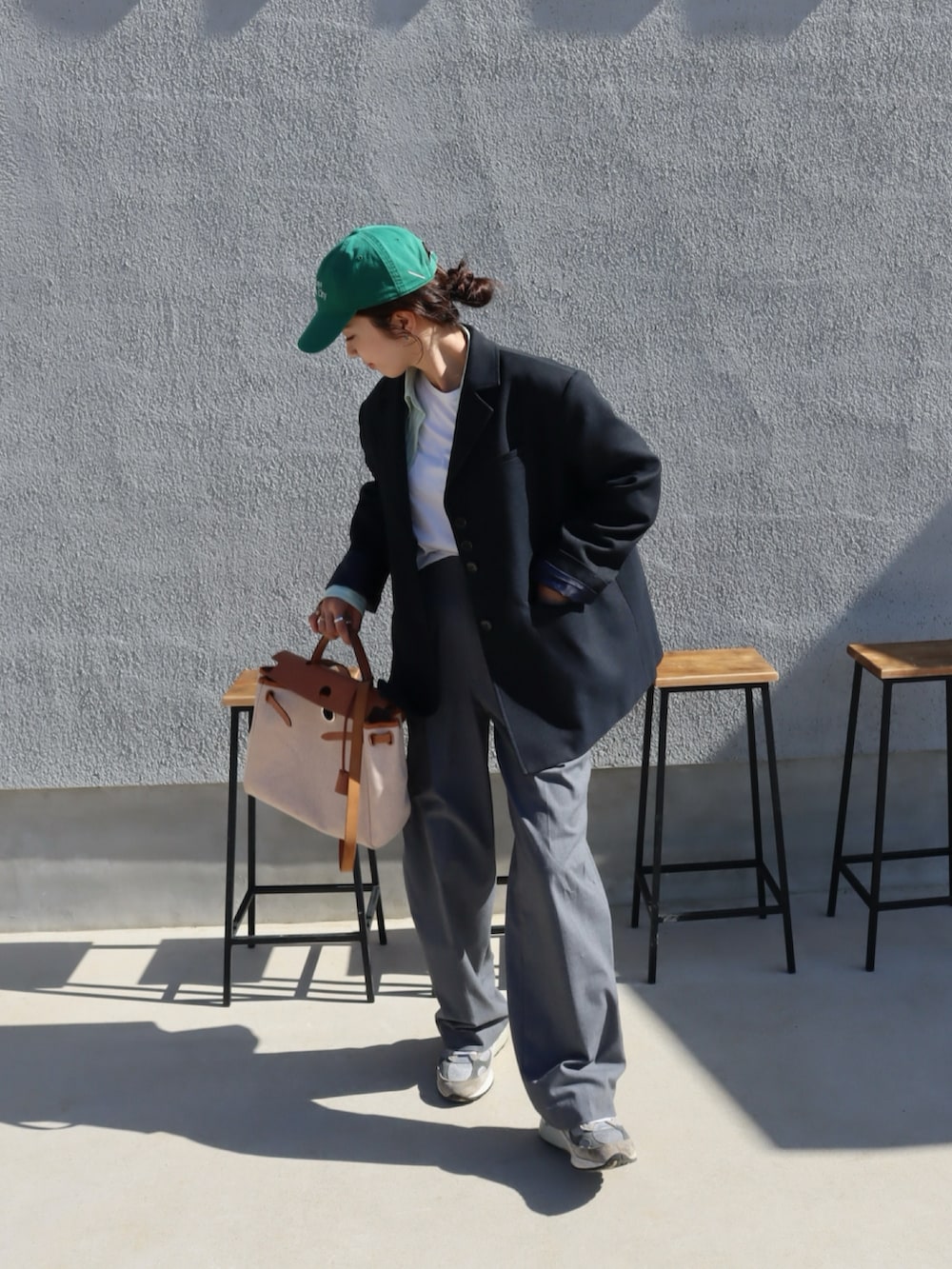 グレー系のスニーカー、ブルー系のテーラードジャケット、グレー系のスラックスを着用したレディースの秋コーディネートの2枚目の写真