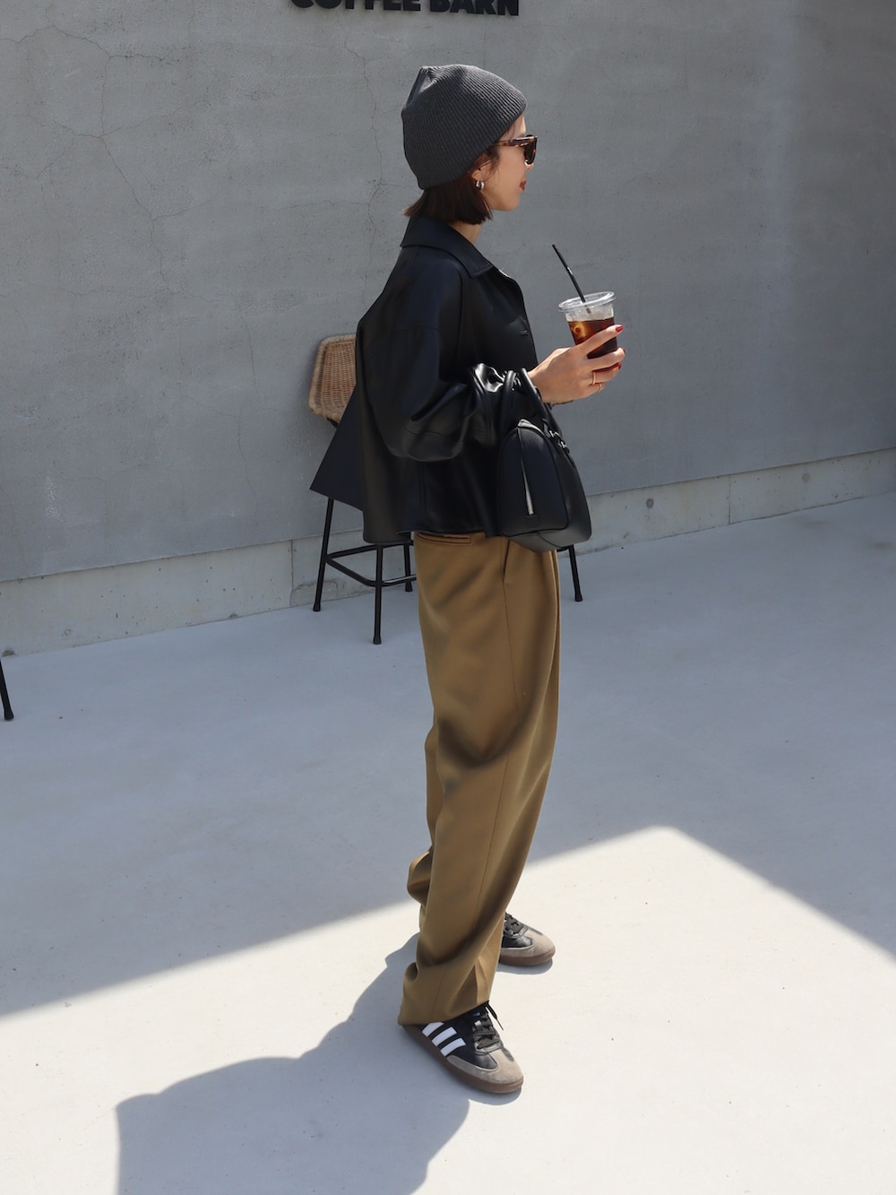 ブラック系のその他アウター、ベージュ系のその他パンツ、ブラック系のスニーカーを着用したレディースの秋コーディネートの2枚目の写真