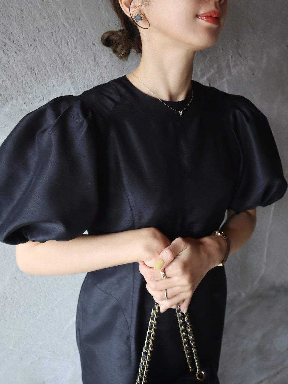 ブラック系のパンプス、ブラック系のドレス、ピンク系のアイシャドウを着用したレディースの春コーディネートの3枚目の写真