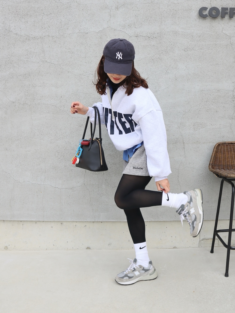 グレー系のスウェット、グレー系のスカート、グレー系のスニーカーを着用したレディースの冬コーディネートの2枚目の写真