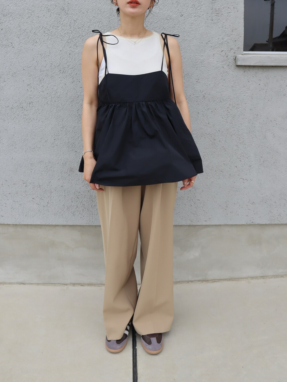 ブラウン系のスニーカー、ブラック系のキャミソール、ベージュ系のスラックスを着用したレディースの春コーディネートの2枚目の写真