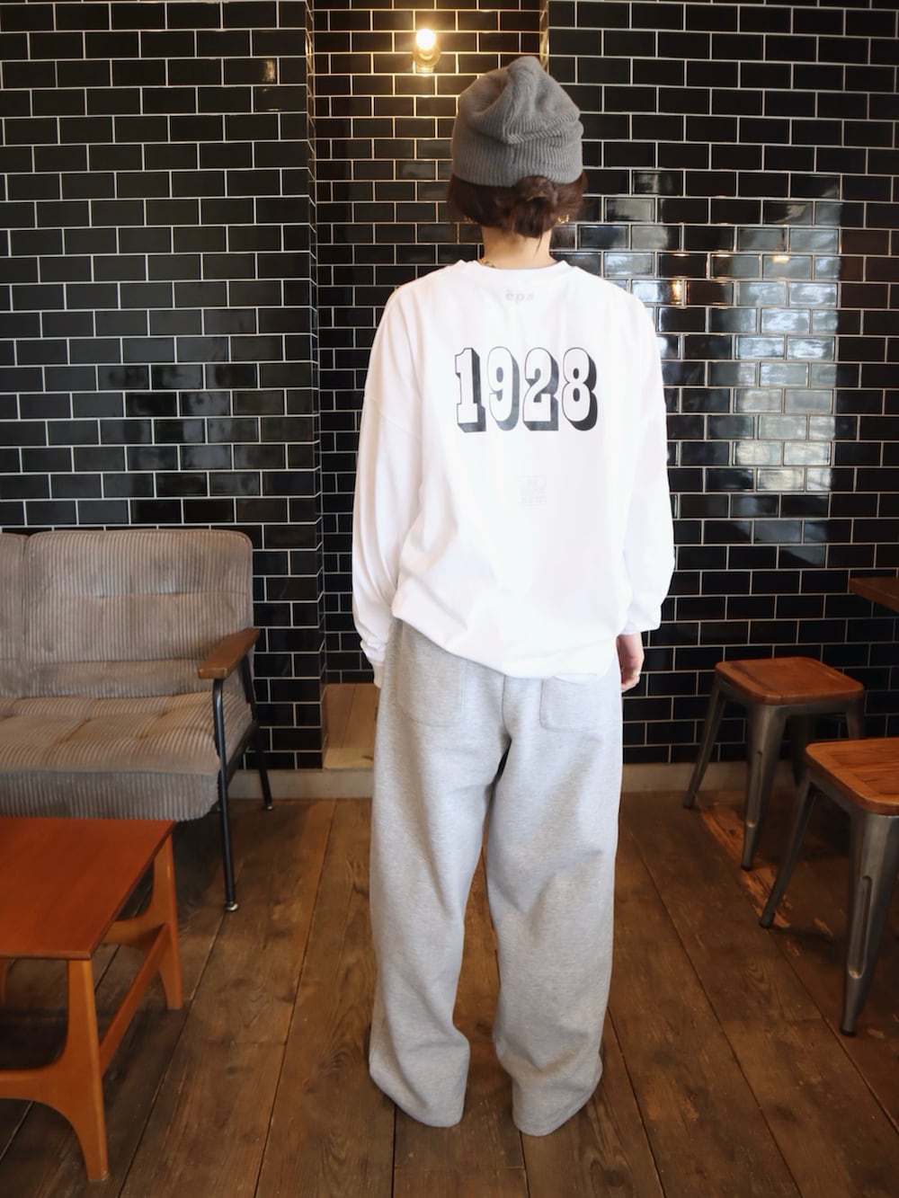 ブラウン系のスニーカー、ホワイト系のTシャツ/カットソー、グレー系のスウェットパンツを着用したレディースの冬コーディネートの2枚目の写真