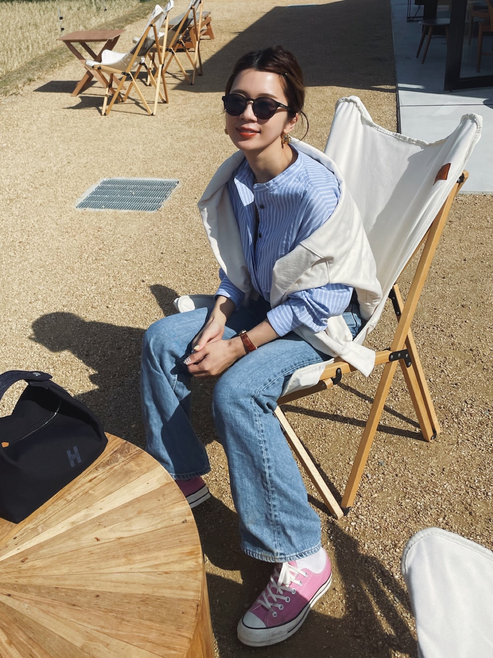 ブルー系のシャツ/ブラウス、ブルー系のデニムパンツ、ピンク系のスニーカーを着用したレディースの春コーディネートの3枚目の写真