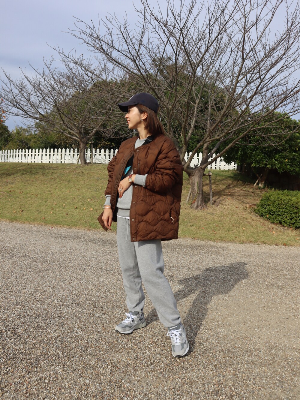 グレー系のスニーカー、ブルー系のキャップ、ホワイト系のインナーウェア/肌着を着用したレディースの秋コーディネートの2枚目の写真