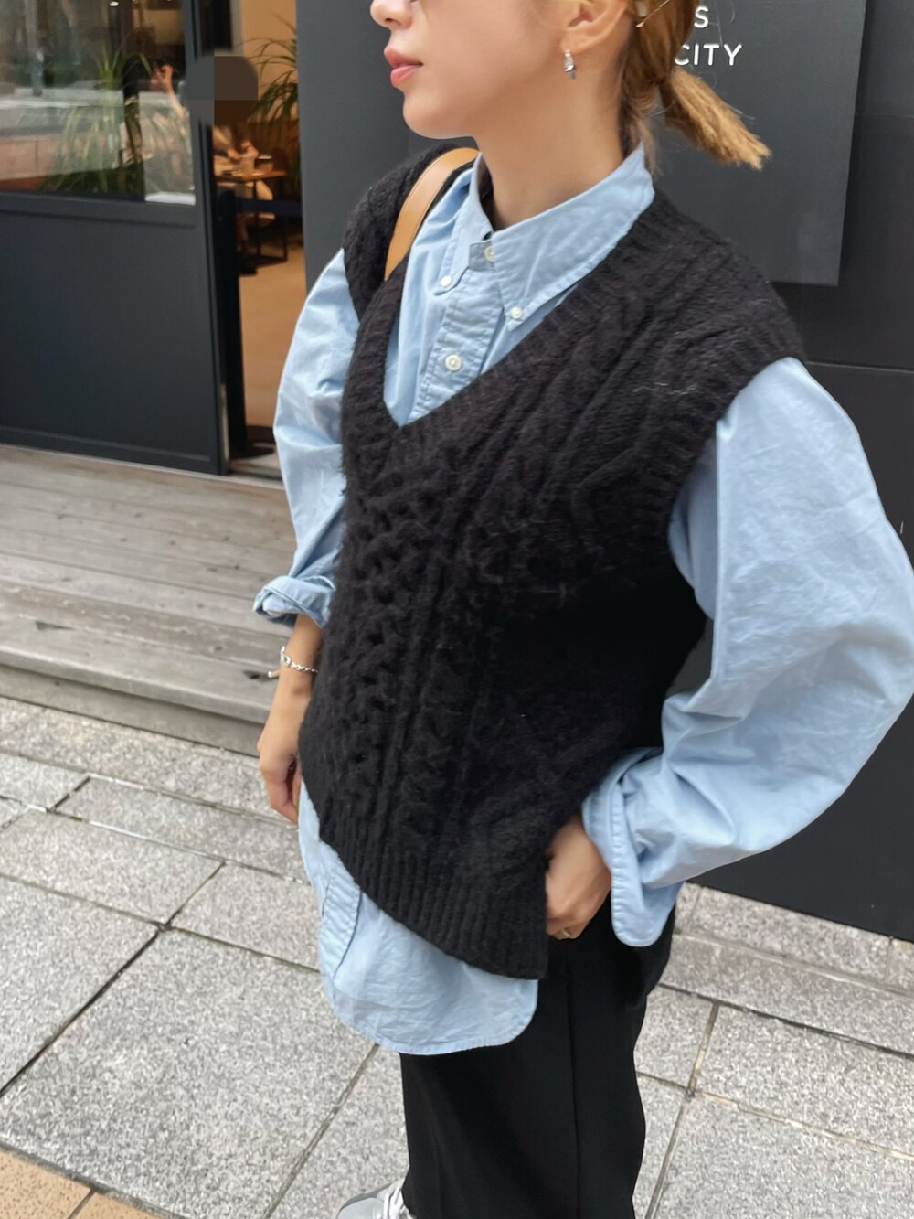 ブラック系のベスト、ブルー系のシャツ/ブラウス、ブラック系のスラックスを着用したレディースの秋コーディネートの2枚目の写真