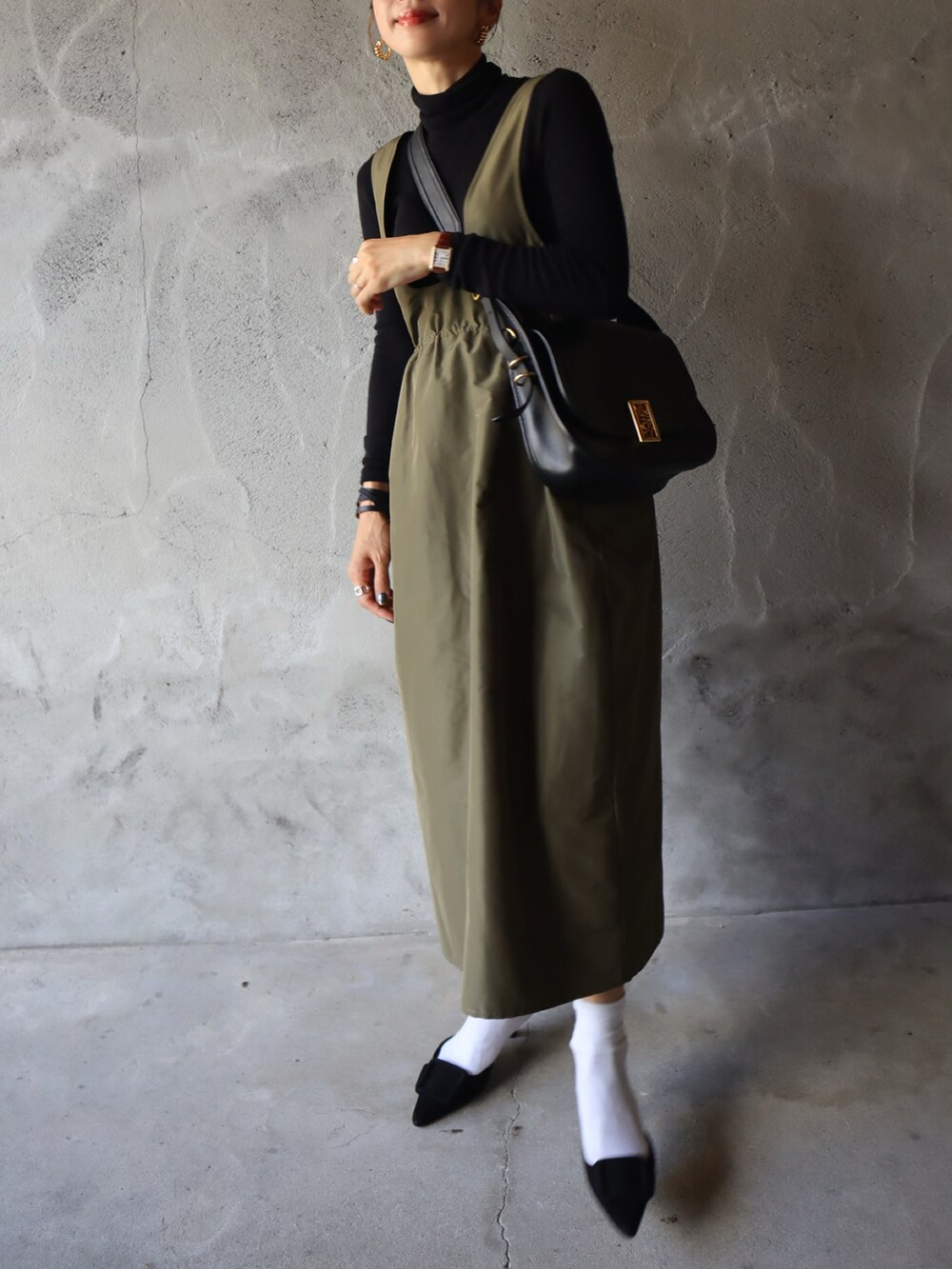 ブラック系のニット/セーター、グリーン系のスカート、ブラック系のシューズを着用したレディースの秋コーディネートの2枚目の写真