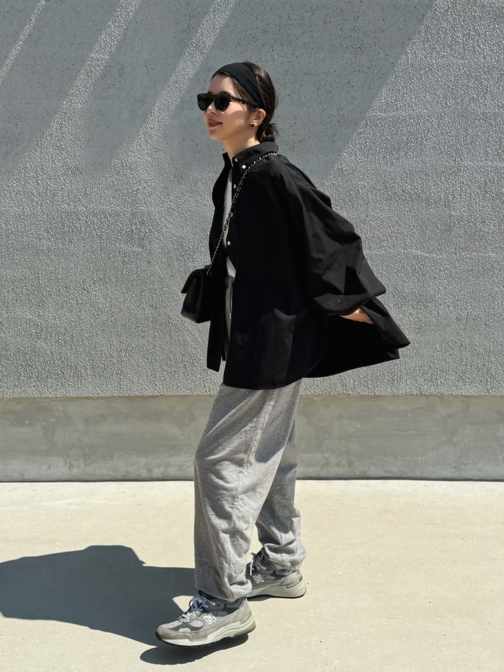 ブラック系のシャツ/ブラウス、グレー系のスウェットパンツ、グレー系のスニーカーを着用したレディースの秋コーディネートの3枚目の写真