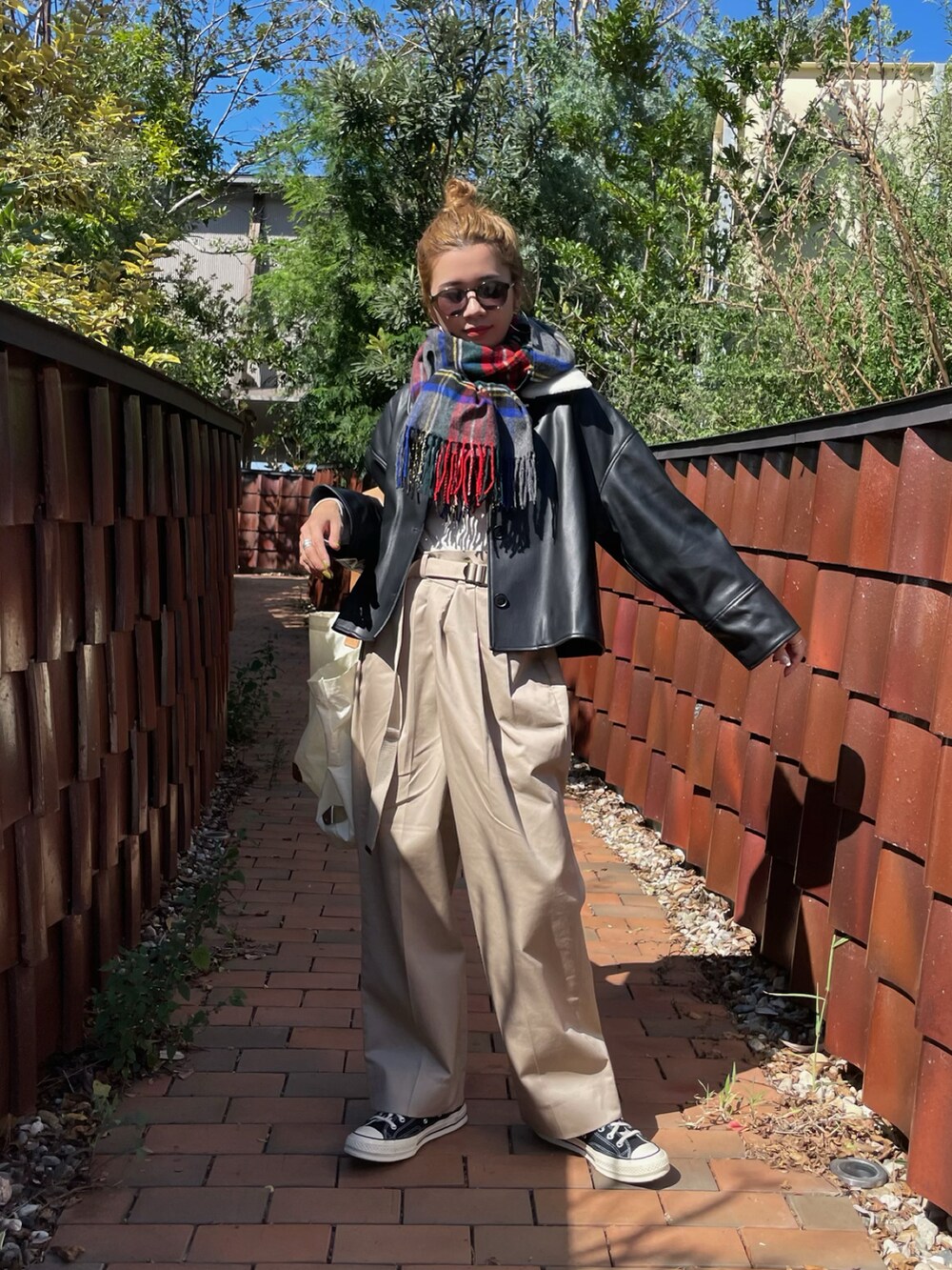 ブラック系のその他アウター、ベージュ系のチノパンツ、ブラック系のスニーカーを着用したレディースの秋コーディネートの2枚目の写真