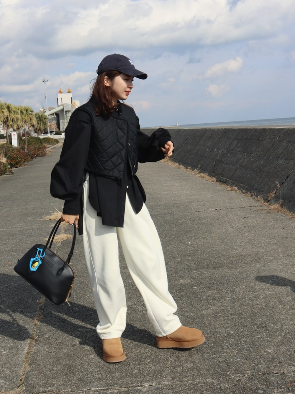 ホワイト系のスウェットパンツ、ブラウン系のブーツ、ブラック系のシャツ/ブラウスを着用したレディースの冬コーディネートの2枚目の写真