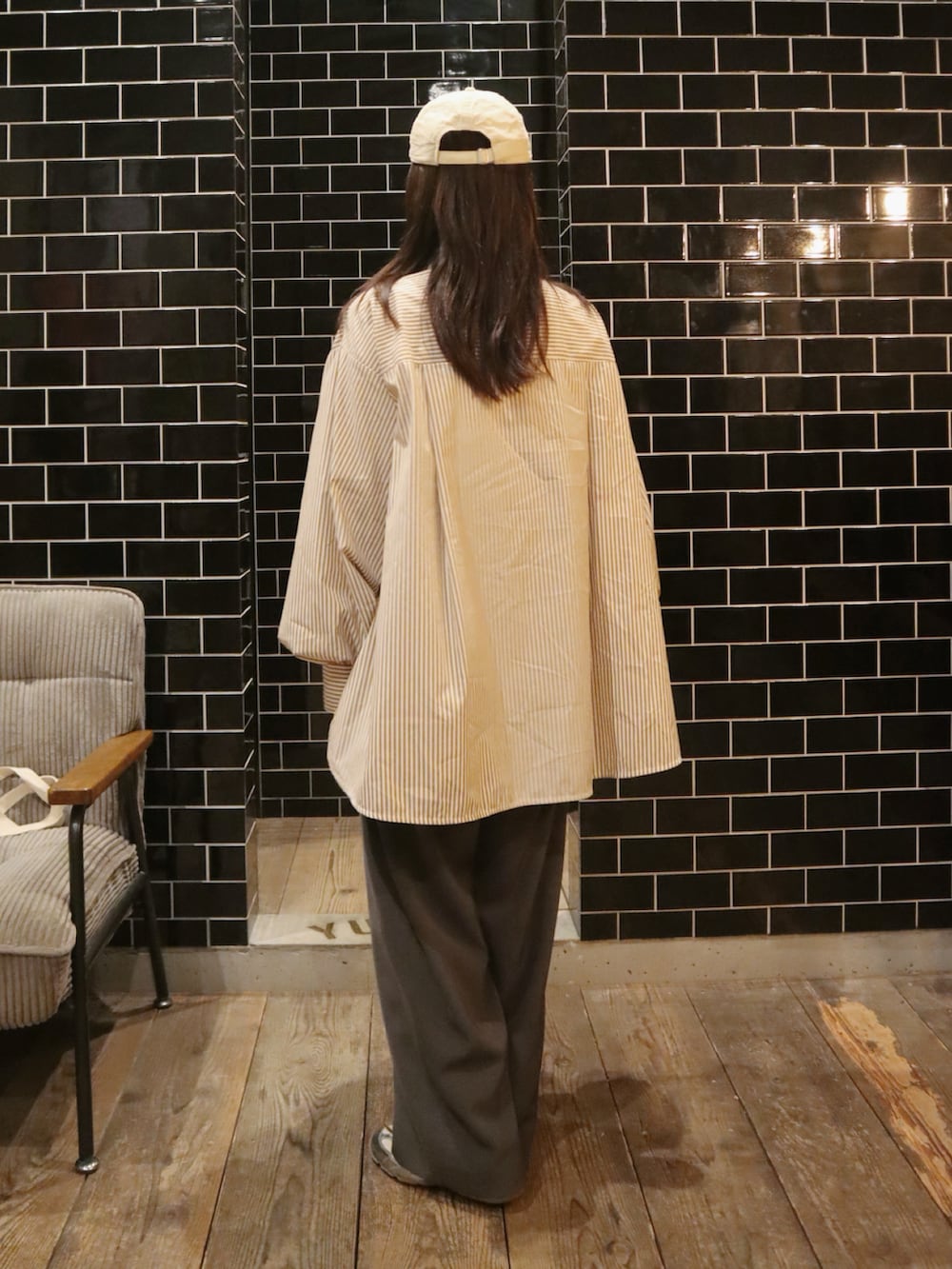 ブラウン系のシャツ/ブラウス、グレー系のスラックス、シルバー系のスニーカーを着用したレディースの冬コーディネートの3枚目の写真