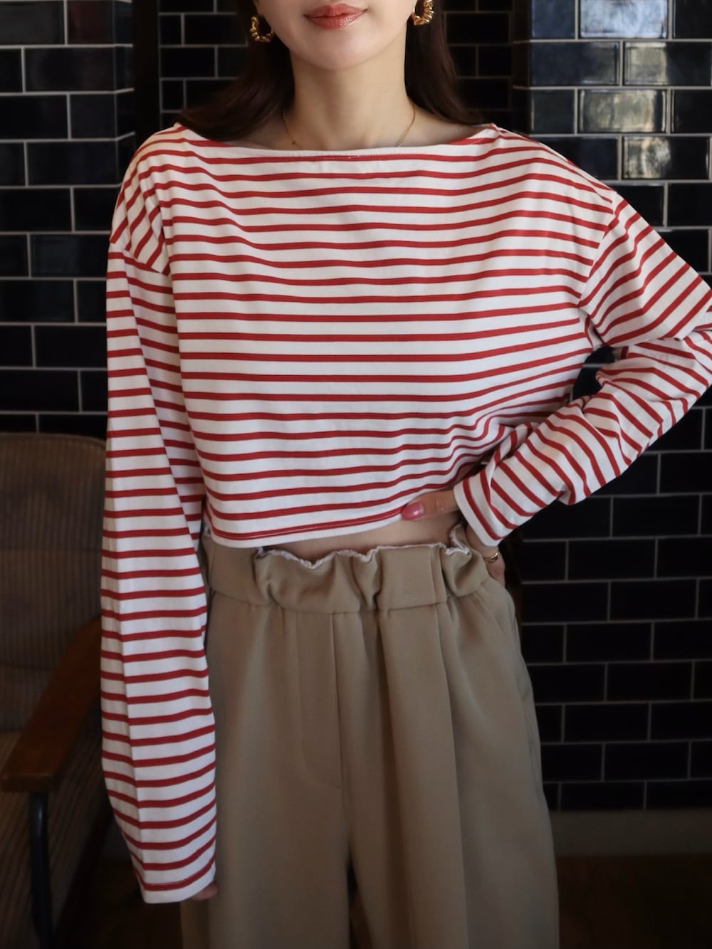 レッド系のTシャツ/カットソー、ベージュ系のスラックスを着用したレディースの春コーディネートの2枚目の写真