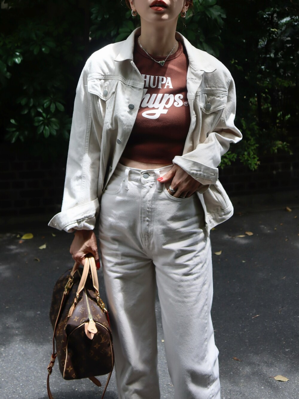 ブラウン系のTシャツ/カットソー、ホワイト系のデニムパンツ、ブラウン系のサンダルを着用したレディースの夏コーディネートの2枚目の写真