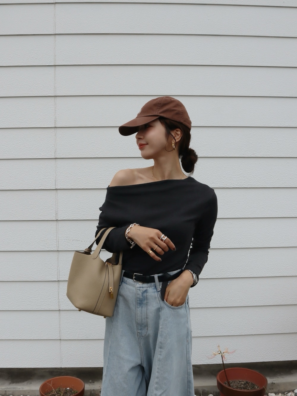 グレー系のTシャツ/カットソー、ブルー系のデニムパンツ、ブラウン系のスニーカーを着用したレディースの秋コーディネートの3枚目の写真