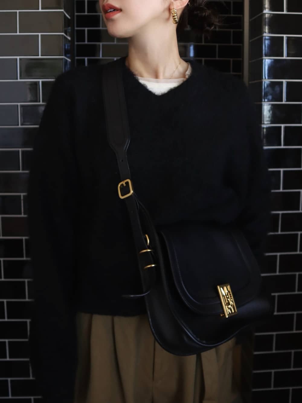 ブラック系のニット/セーター、ベージュ系のその他パンツ、ホワイト系のタンクトップを着用したレディースの夏コーディネートの2枚目の写真