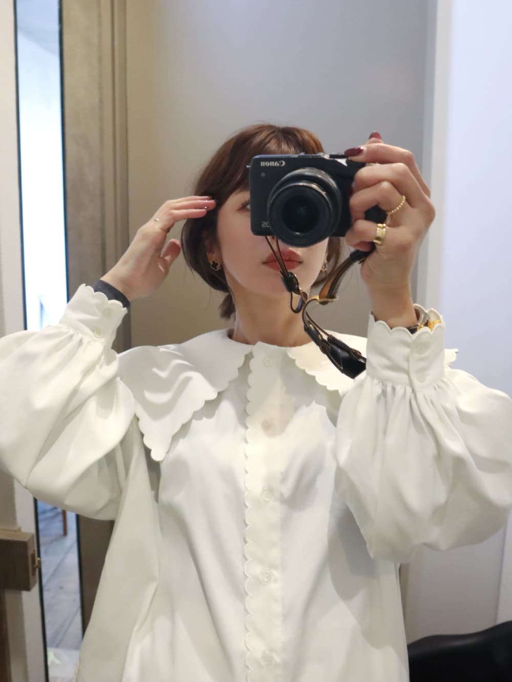 ホワイト系のシャツ/ブラウス、ホワイト系のスラックス、ブラック系のハンドバッグを着用したレディースの冬コーディネートの2枚目の写真