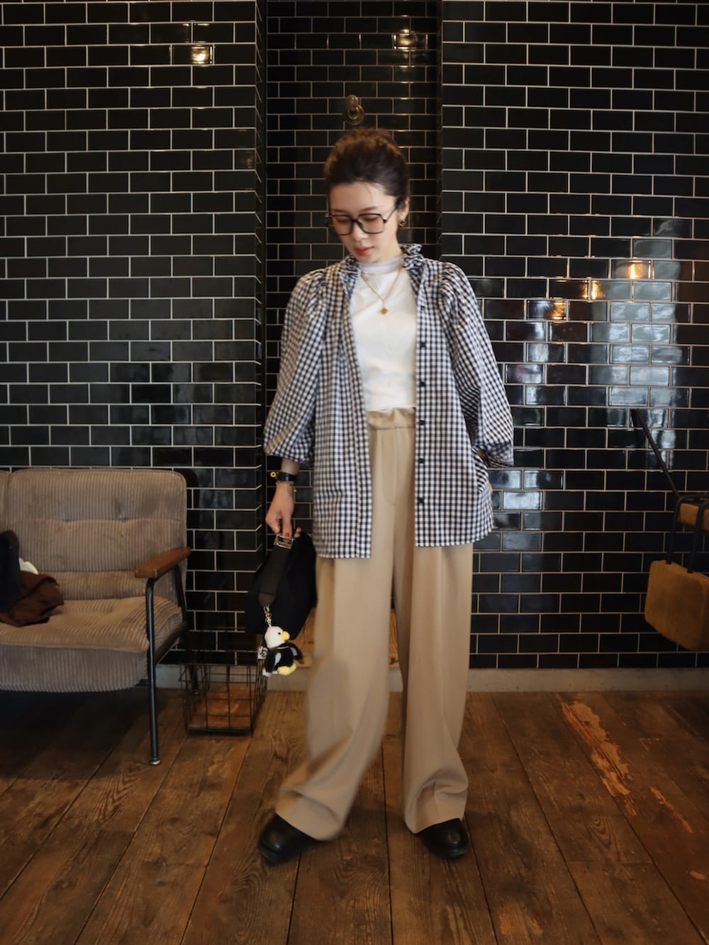 ブラック系のシャツ/ブラウス、ベージュ系のスラックスを着用したレディースの春コーディネートの2枚目の写真