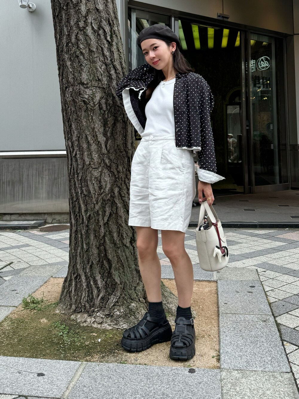 ブラック系のシャツ/ブラウス、ブラック系のサンダル、ブラック系のハンチング/ベレー帽を着用したレディースの夏コーディネートの2枚目の写真