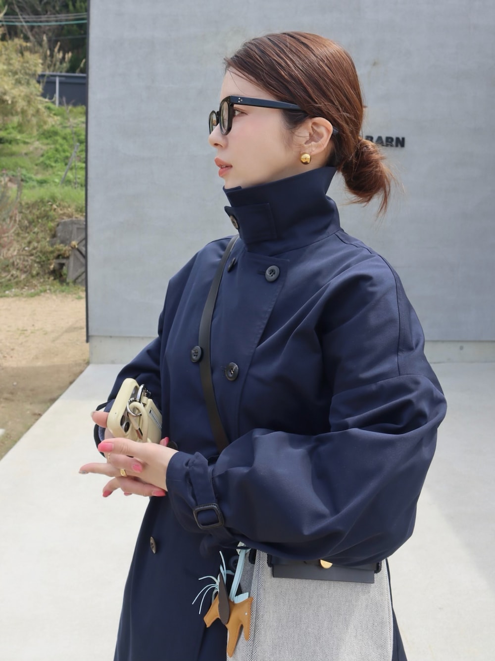 ブルー系のトレンチコート、グレー系のスウェットパンツ、ブラウン系のローファーを着用したレディースの春コーディネートの3枚目の写真